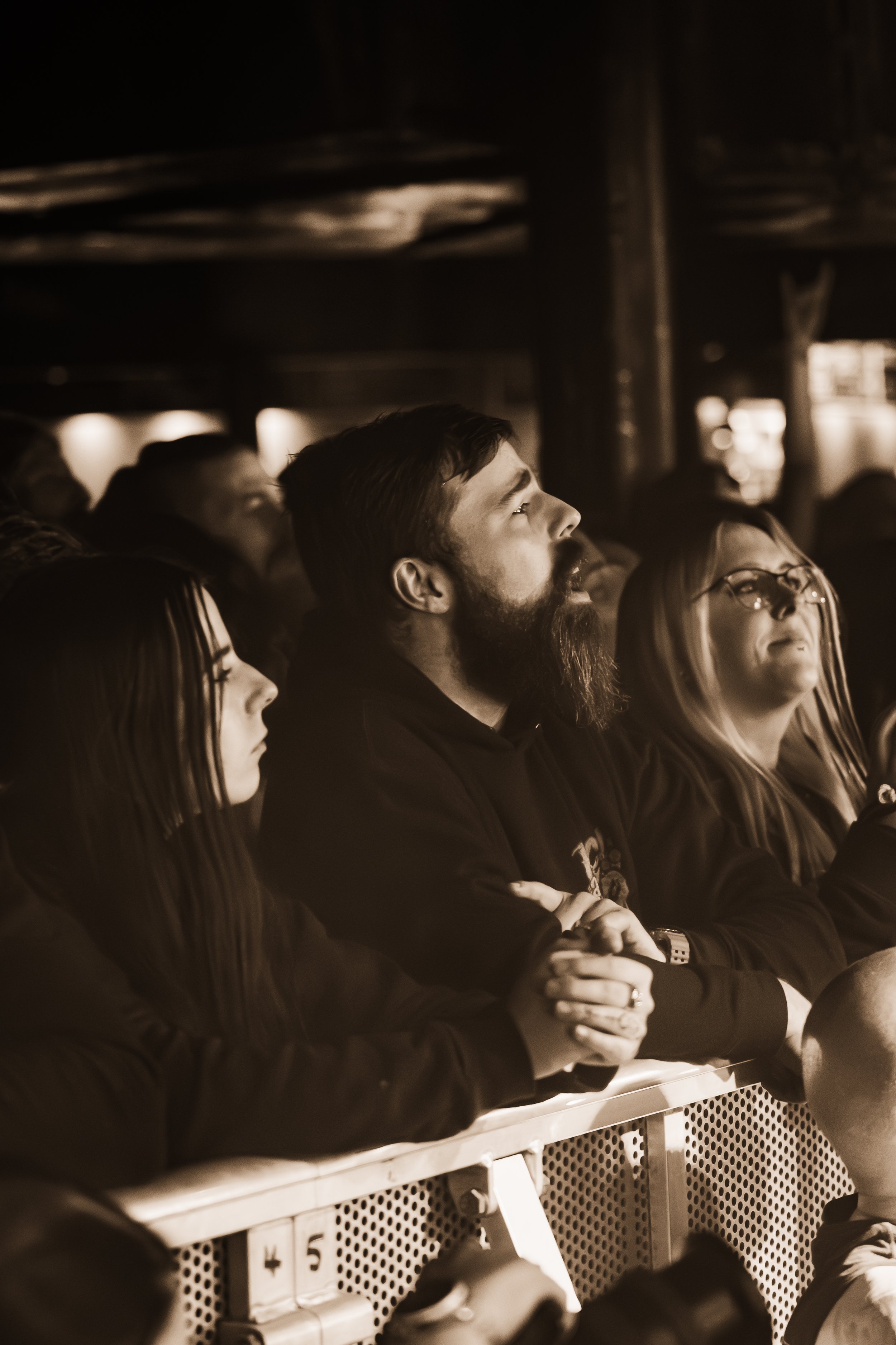 A group of people sitting in a darkened auditorium, watching a performance or presentation attentively.