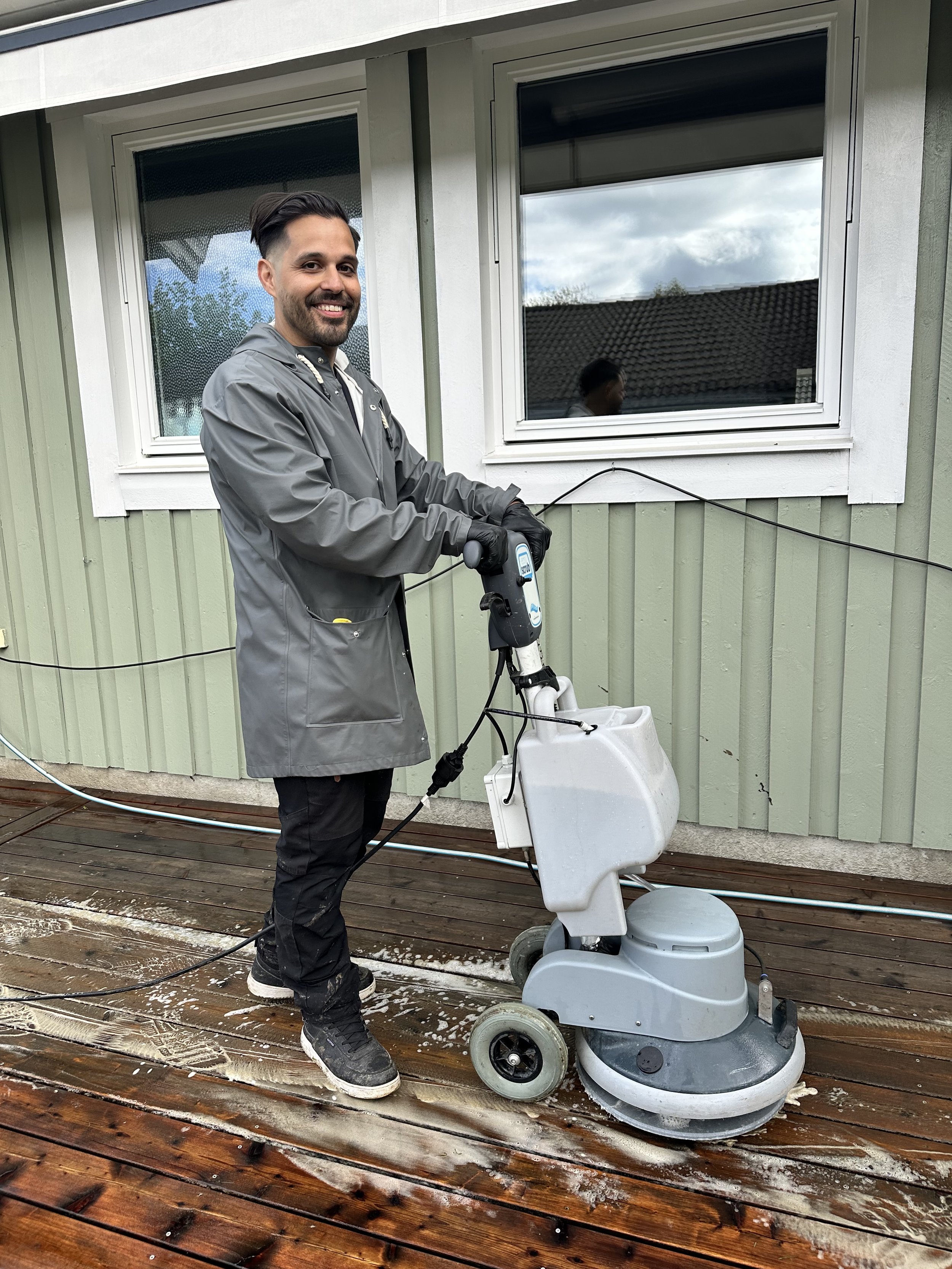 Carlos i full färd med att tvätta en altan i Stockholm