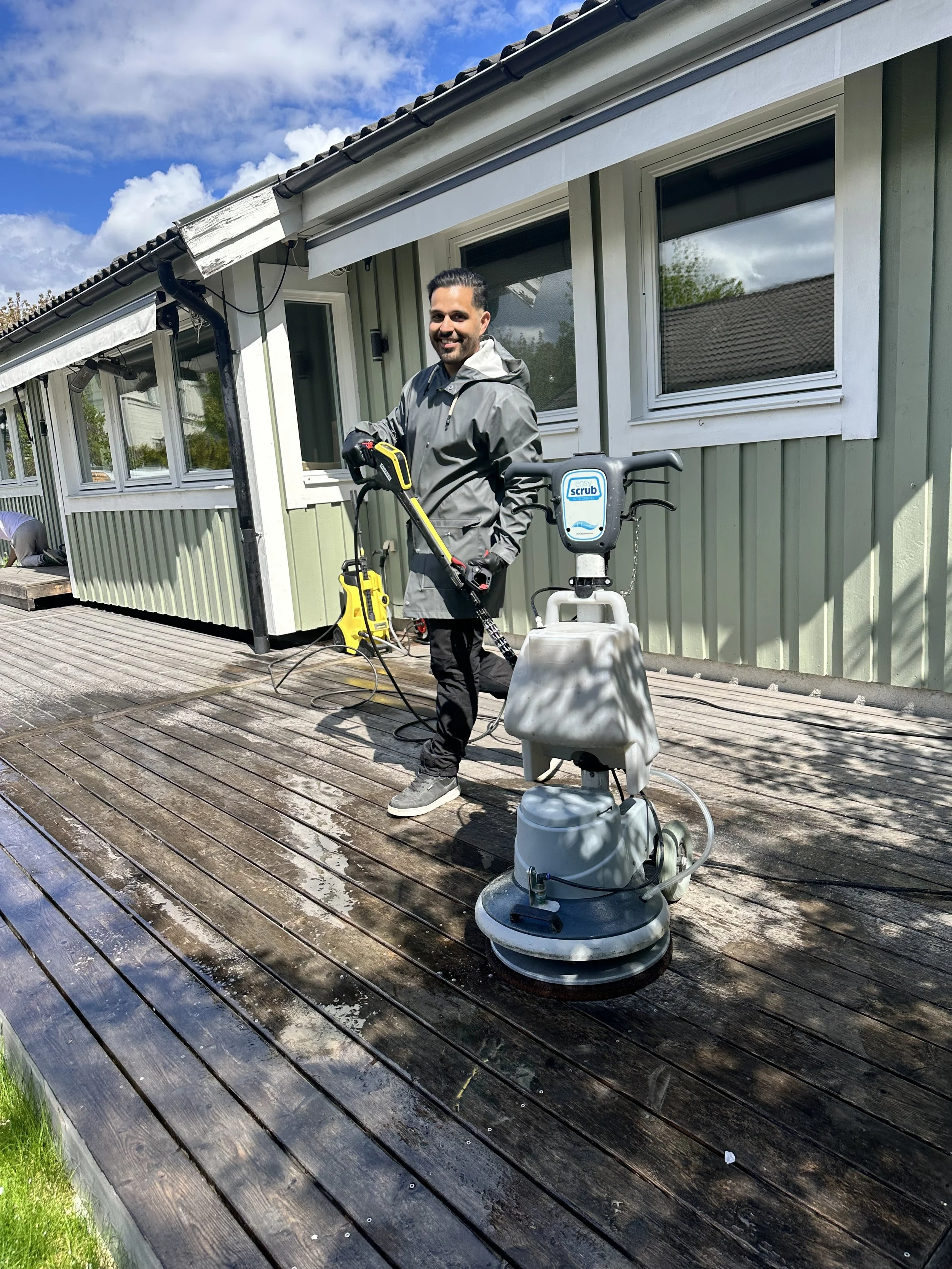 Carlos i full fart med att tvätta en altan