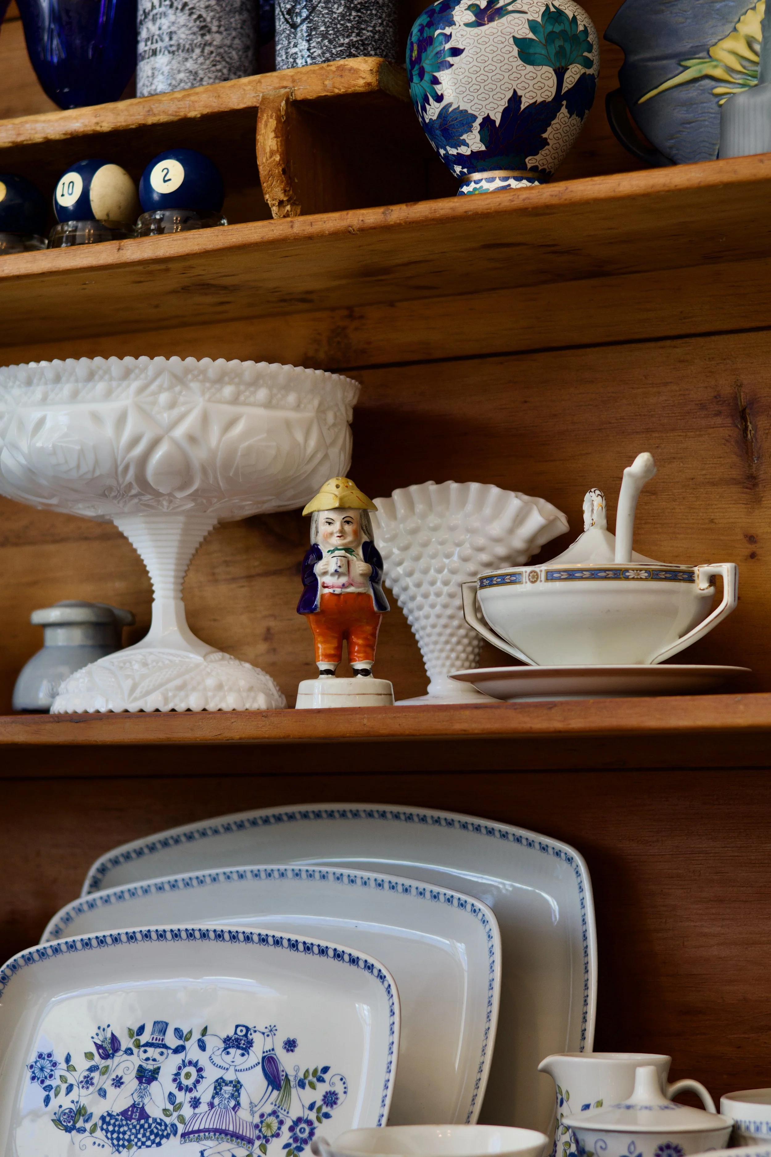 An image of vintage/antique milk glass, pool balls, vases, and dinnerware