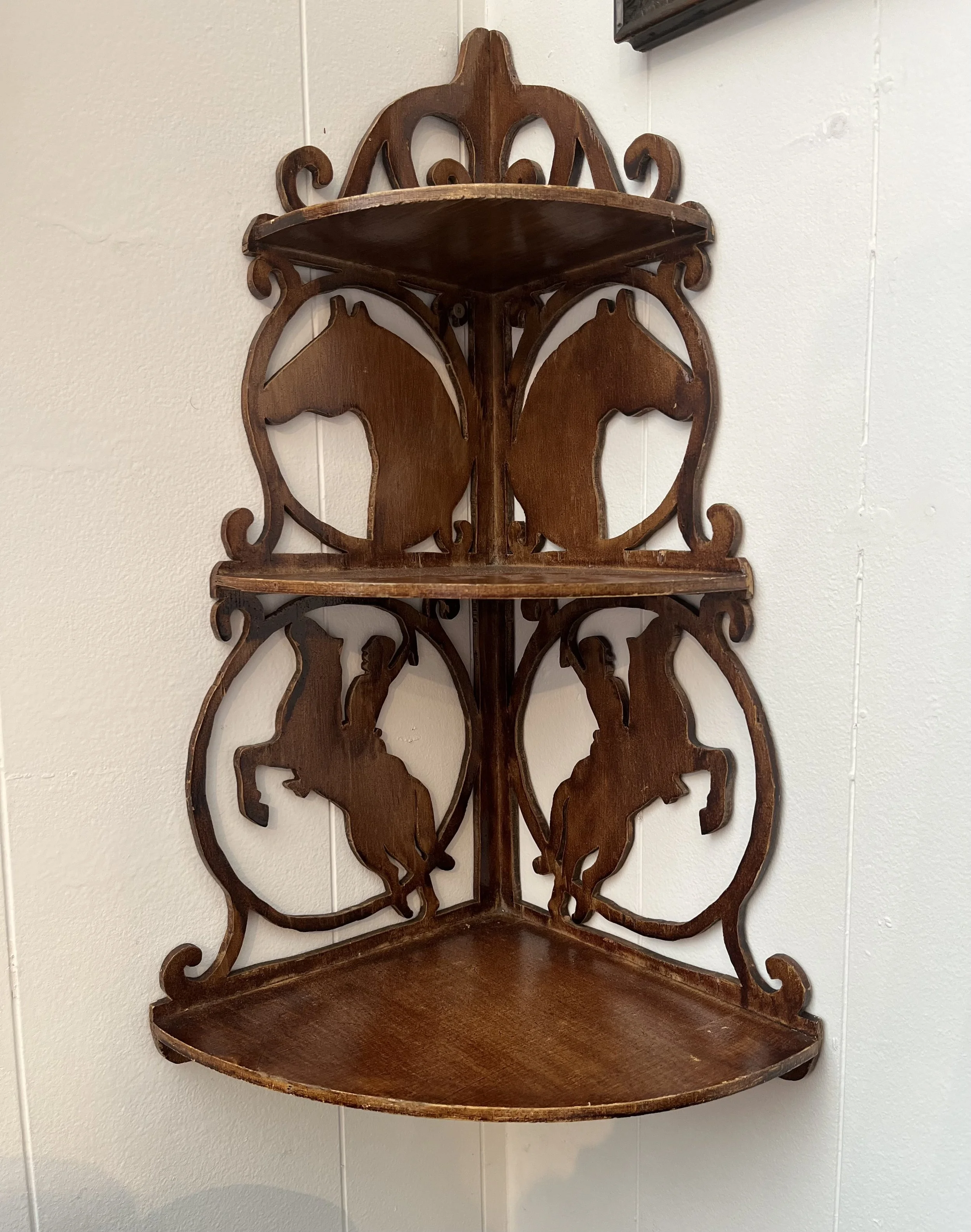 Giddy up! A wonderful small corner shelf with cowboy and horse cutouts.  Original stained finish.  Measures 24" x 15" ($65)