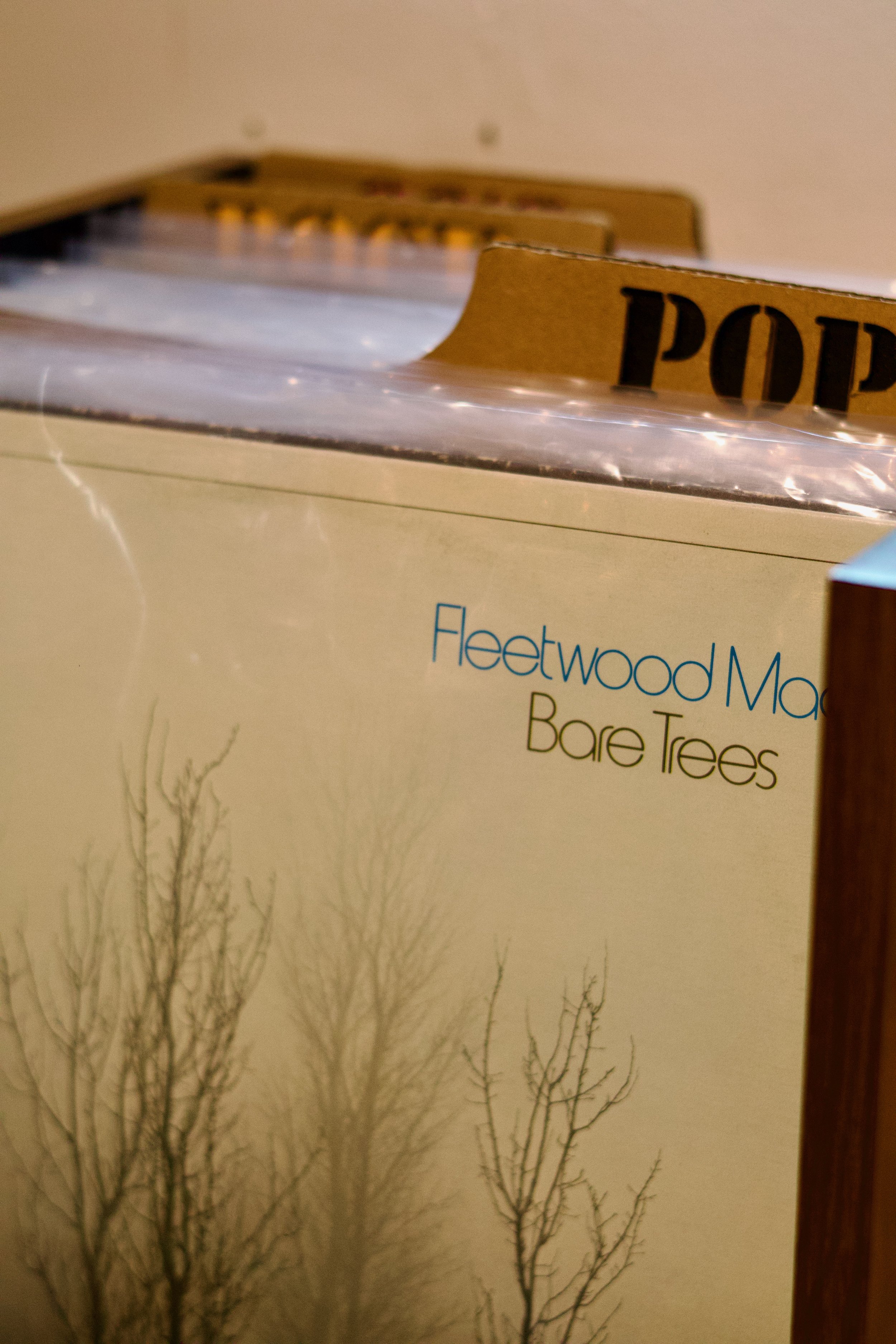 A cardboard box with the words "Fleetworks" and "Bare Trees" on it, situated next to a plastic container labeled "POP".