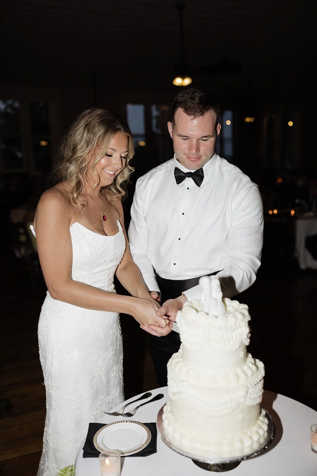Bride and groom cutting their wedding cake together at reception.