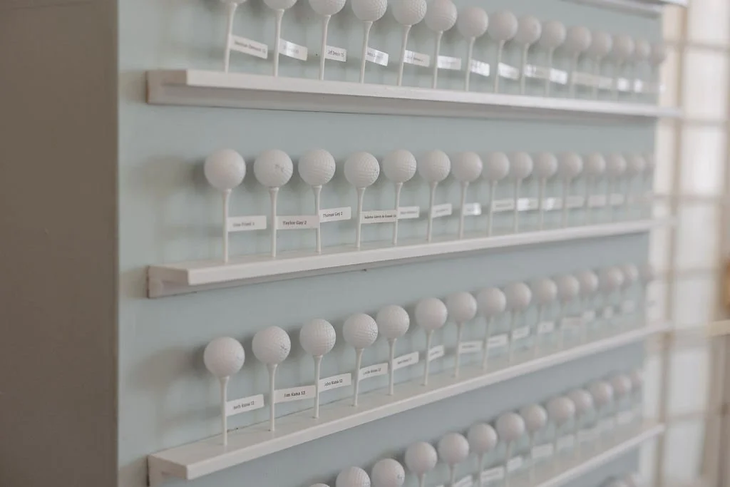 A display of multiple white golf balls arranged on racks with labeled tags.