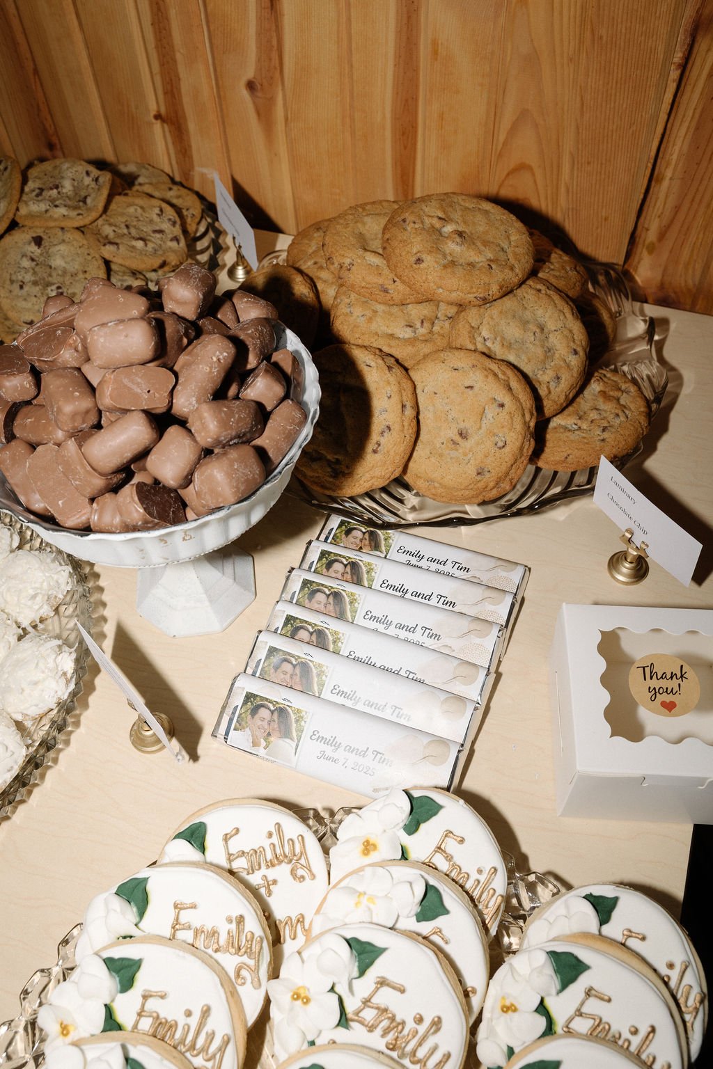 An assortment of cookies, chocolates, and personalized treats on a table at a celebration or event.