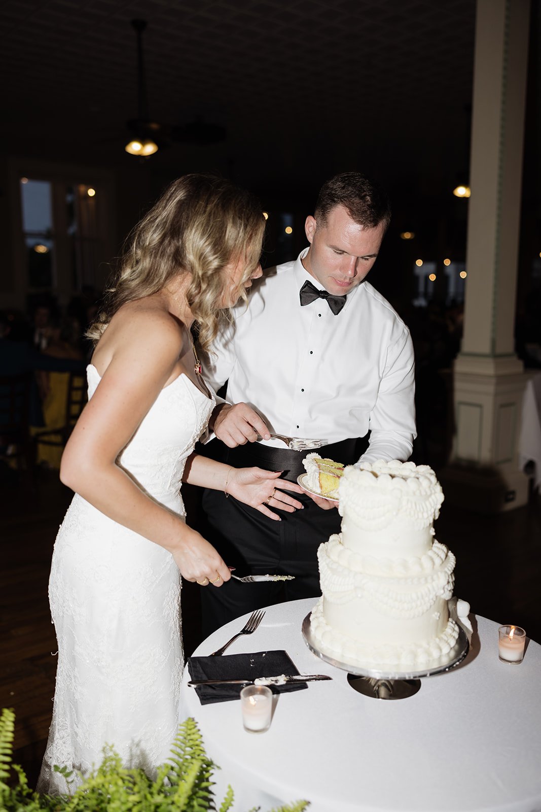 Bride and groom cutting a wedding cake at their reception.