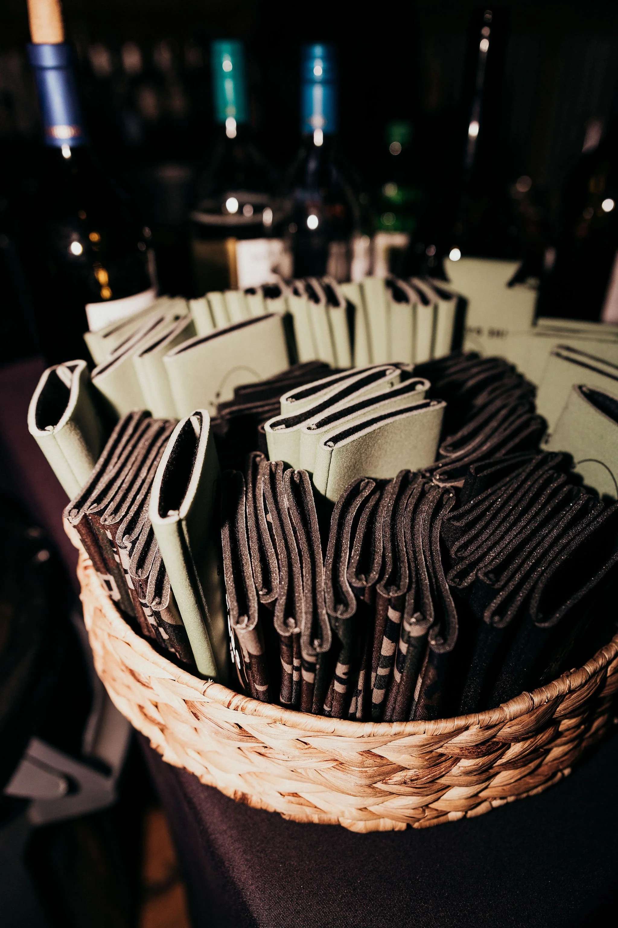 A wicker basket filled with individually wrapped chocolate and vanilla-flavored cookies with striped designs.