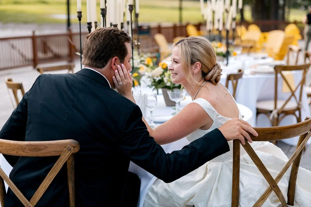 A bride and groom sharing a tender moment at their wedding reception outdoors.