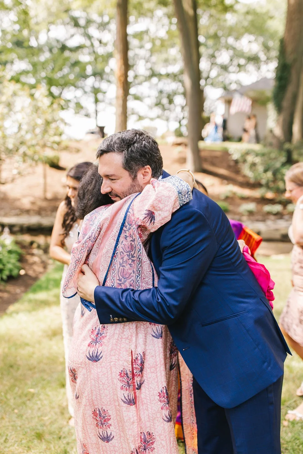 A man and woman hugging outdoors during a gathering or celebration.