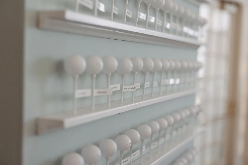 Display of golf balls organized on shelves, each labeled with names.
