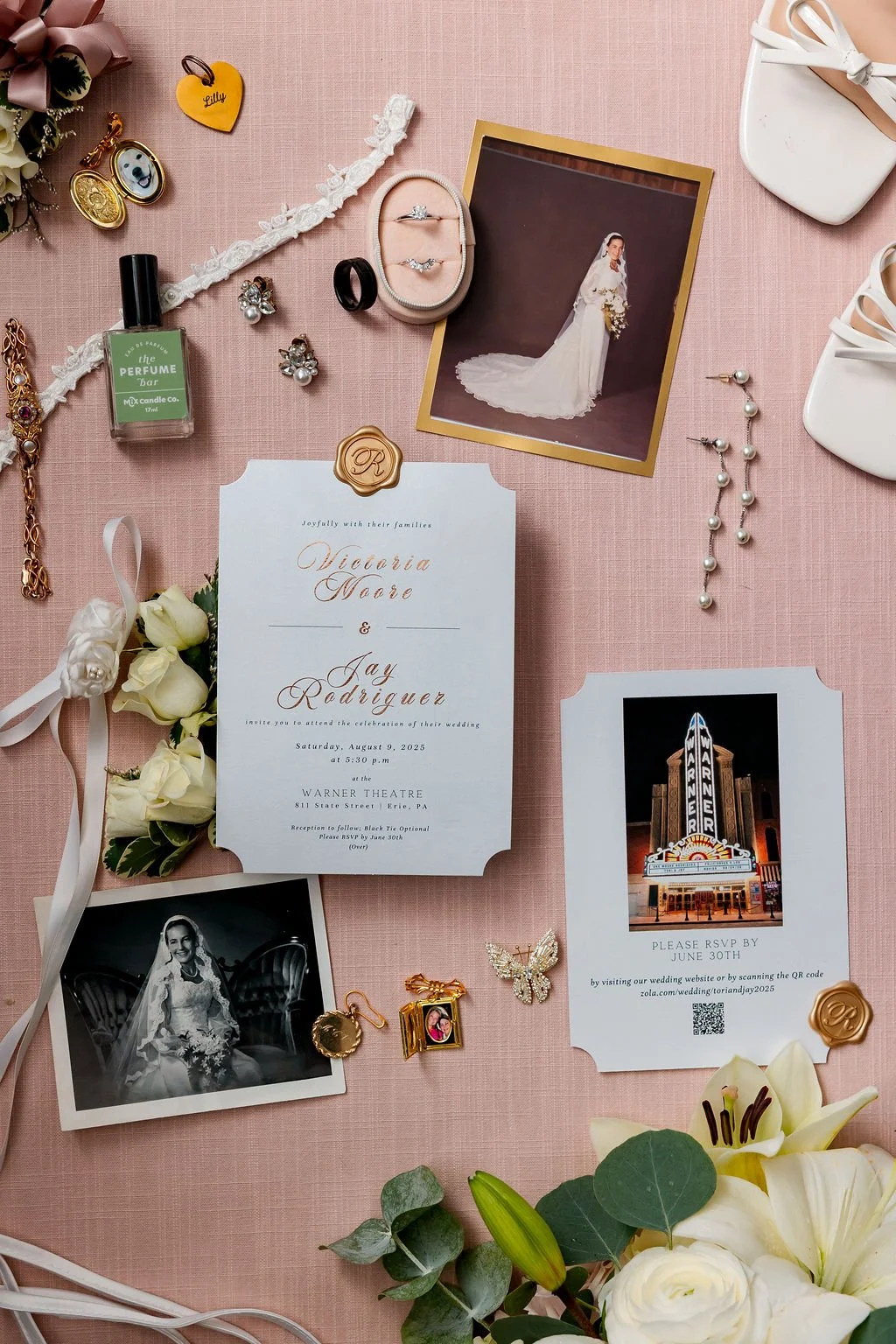 Wedding invitation and memorabilia laid out on a pink background, including a wedding photo of the bride in a wedding dress, a royal theater ticket, jewelry, a corsage, white shoes, and flowers.