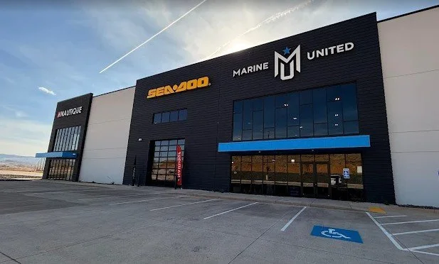 Exterior view of a large warehouse building with the signs 'Seaside', 'Marine United', and 'Maritime' on it, and a handicap parking space in the foreground.
