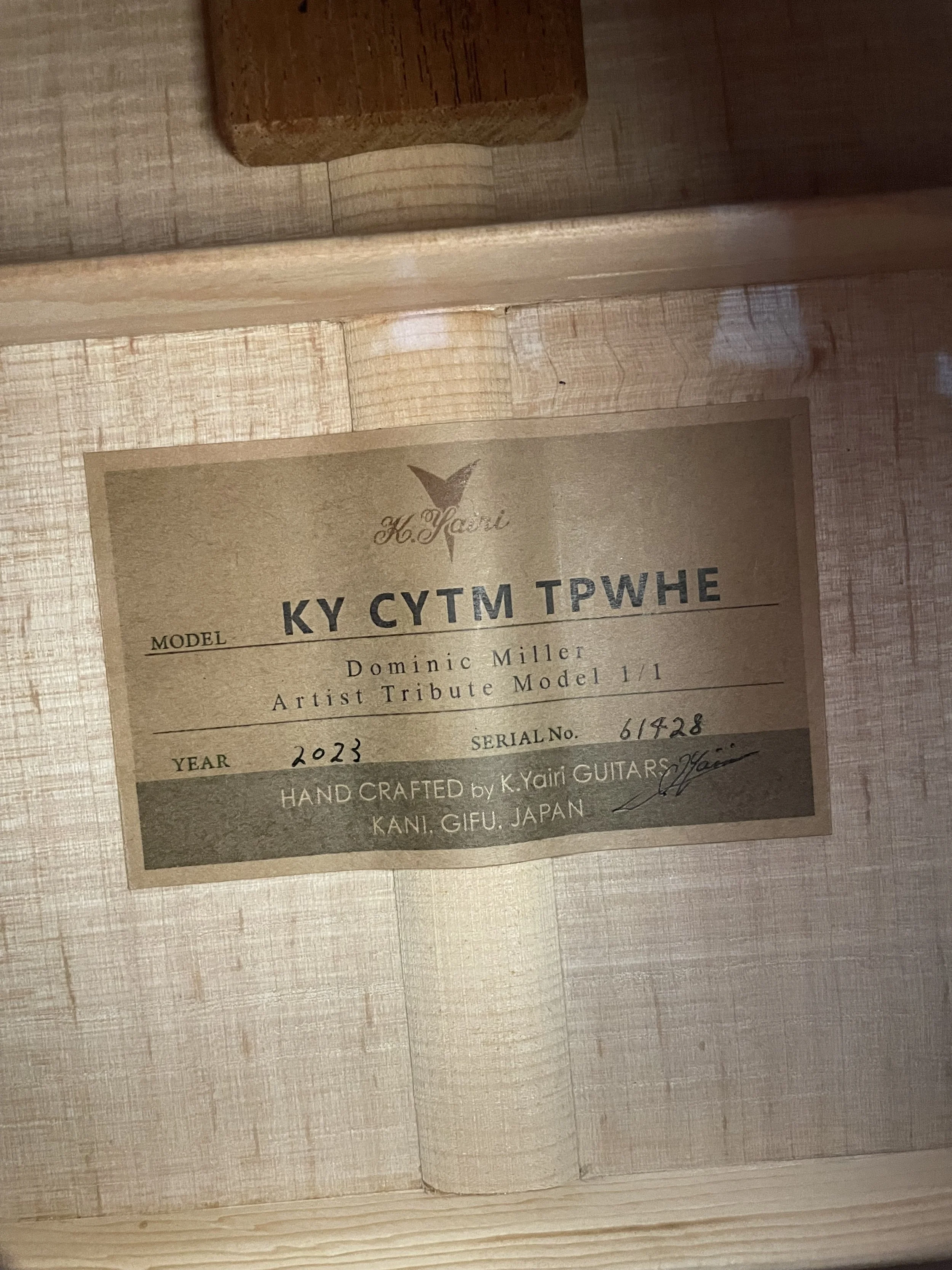 Close-up of a certificate or label for a handmade guitar, model KY CYUM TPWHE, made by K. Yairi Guitars in Kanagawa, Japan, with a serial number 617428, dated 2023.