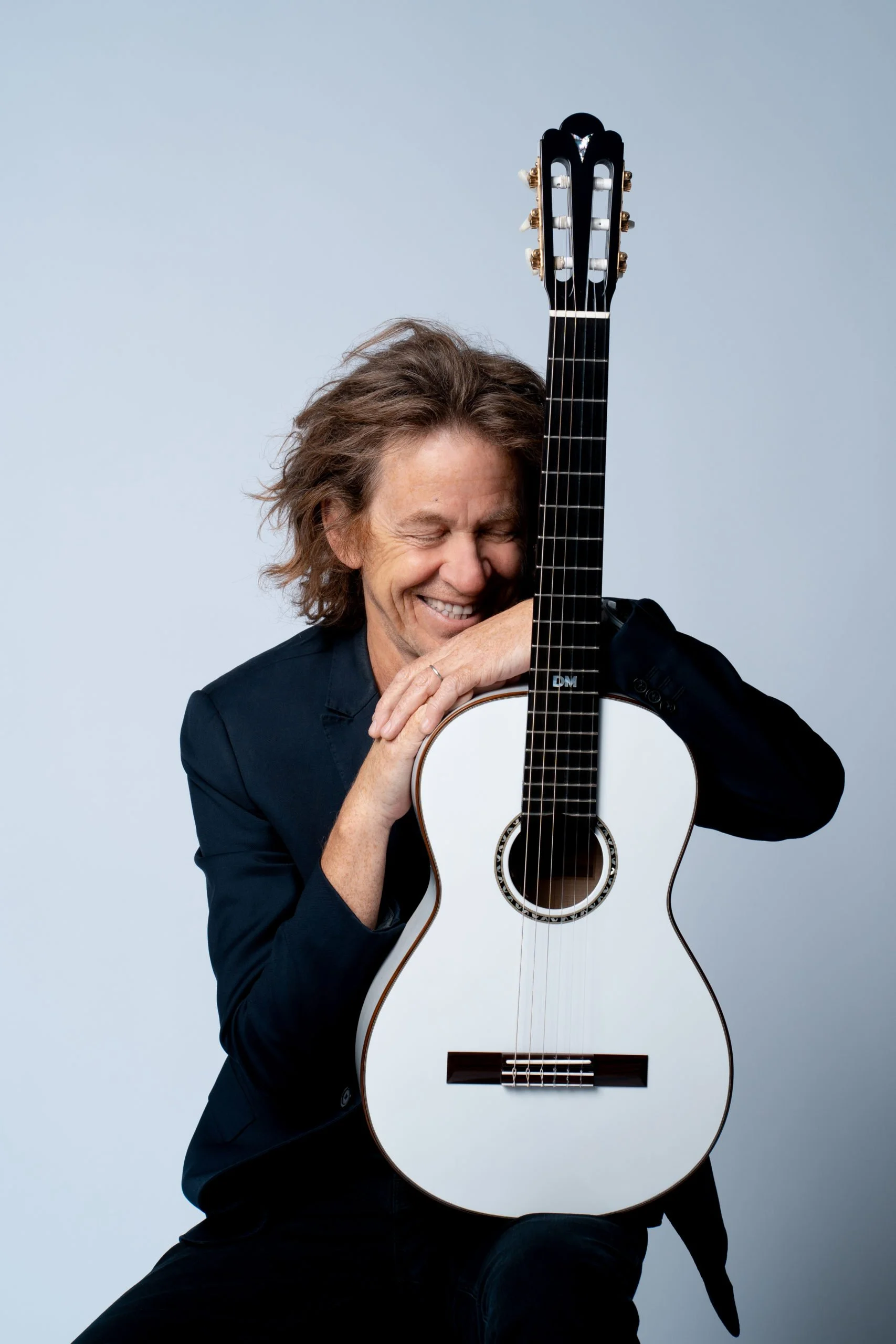 Dominic Miller is posing with his K yairi tribute guitar, also known as grace.