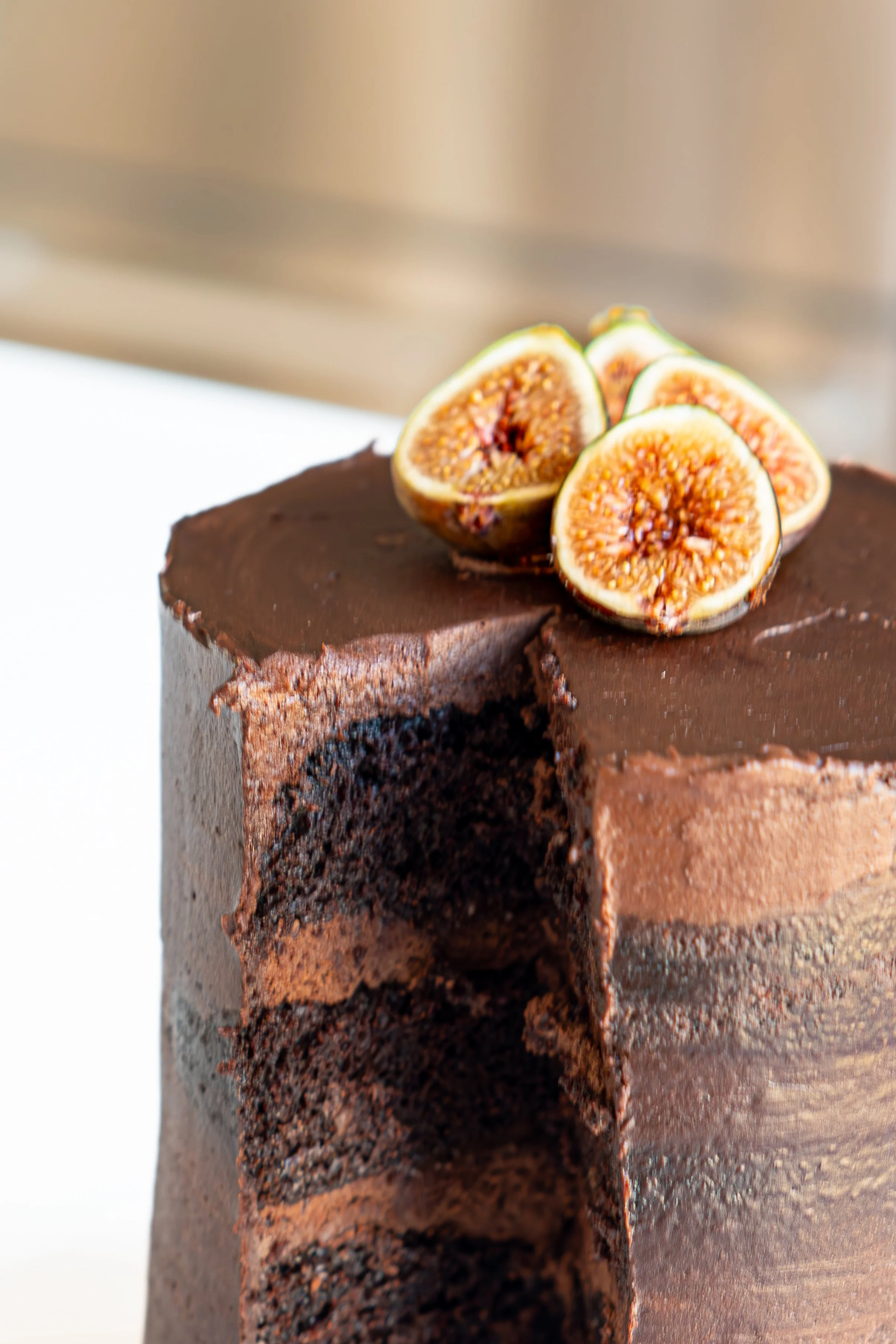 A close-up of a chocolate cake topped with halved figs.