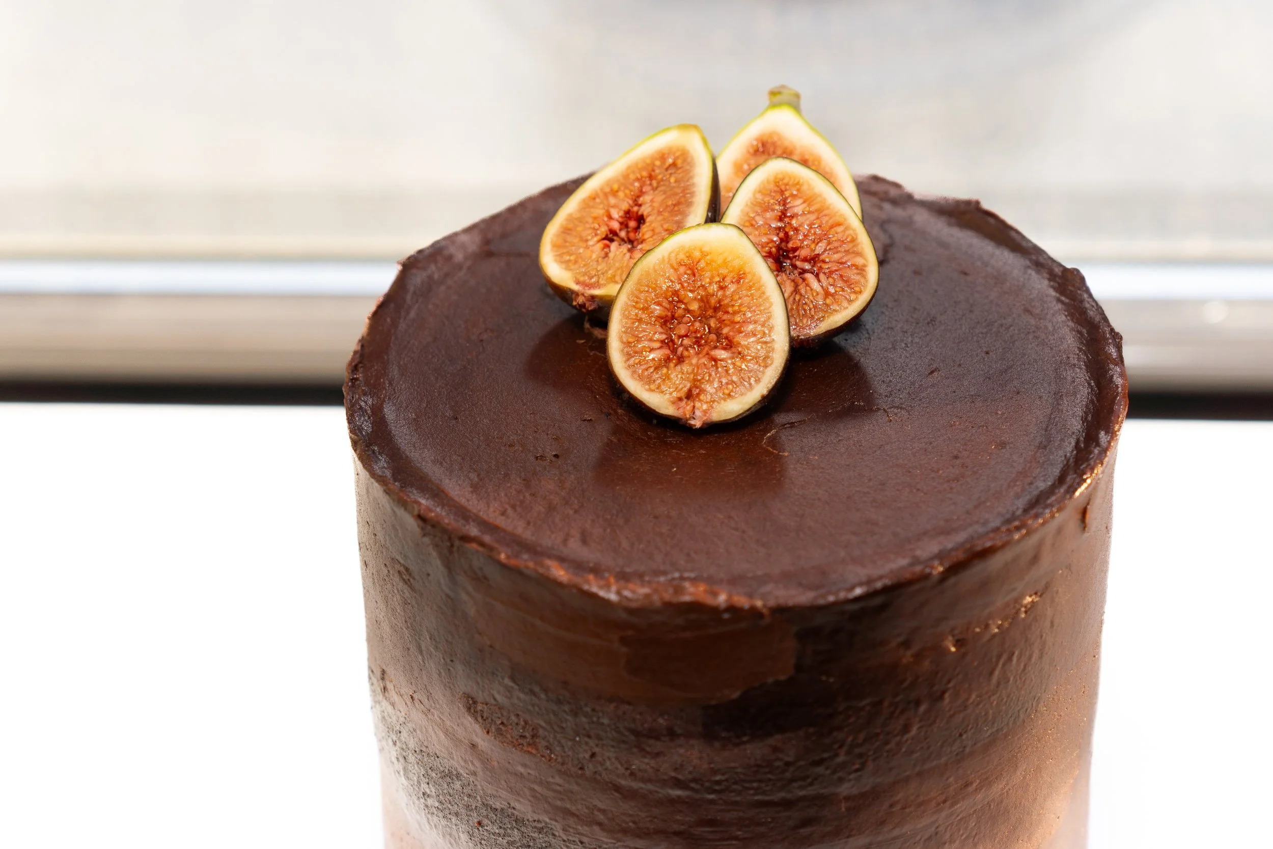 Chocolate cake topped with sliced fresh figs.