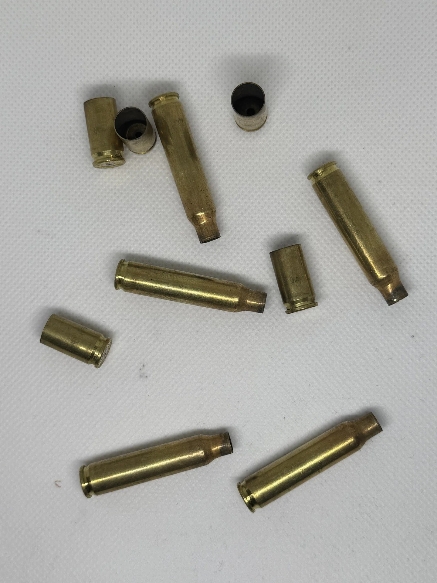 Several spent brass shell casings scattered on a white surface.