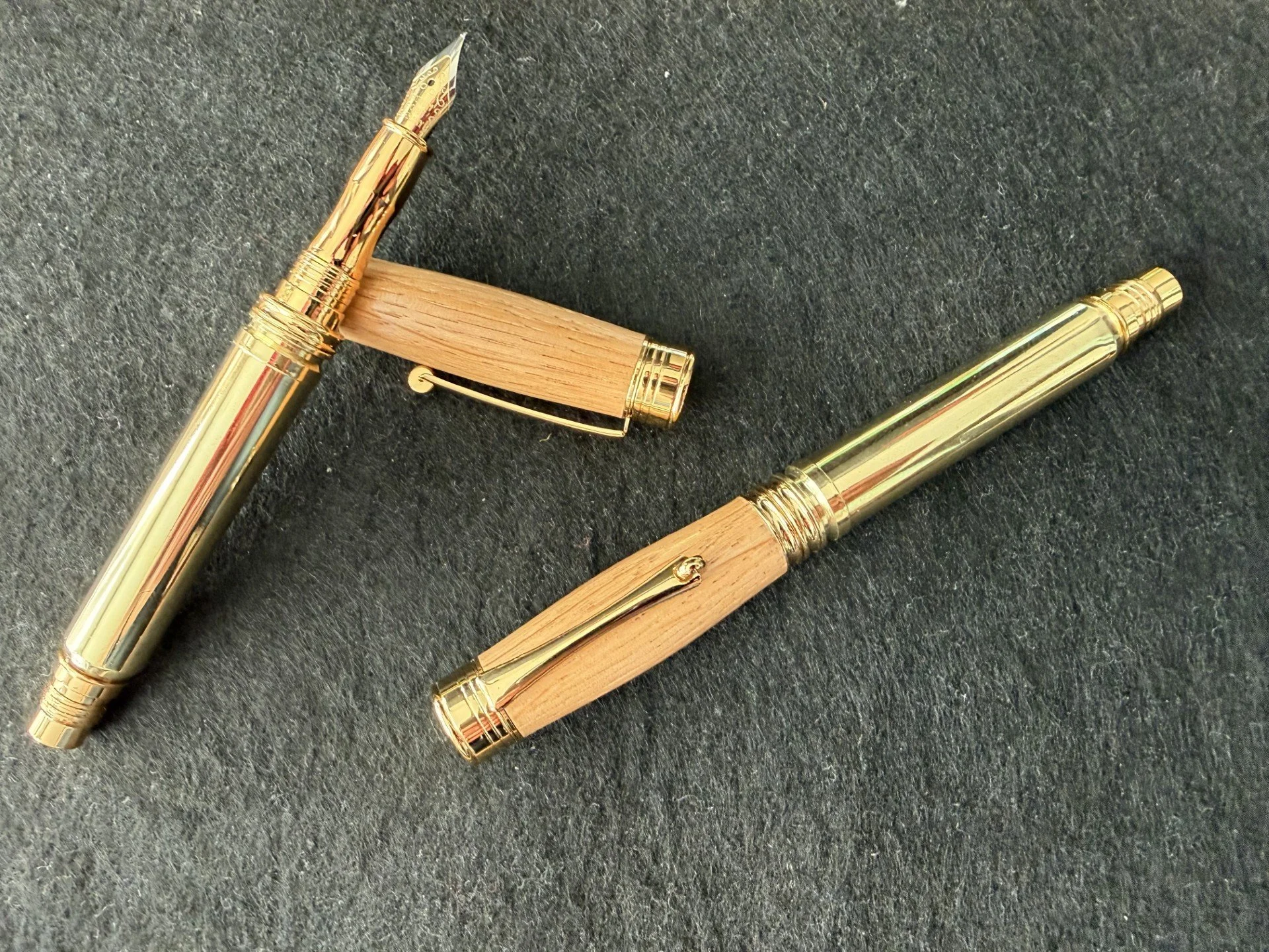 The Whisky shot pen.
Two Whisky Shot fountain pens.  The shafts are made from once fired 300 Men casings and the lid from white oak sourced from reclaimed Dalmore Whisky cask staves.
