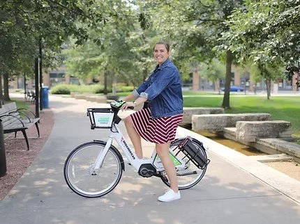Woman on rideshare bike smiling at camera