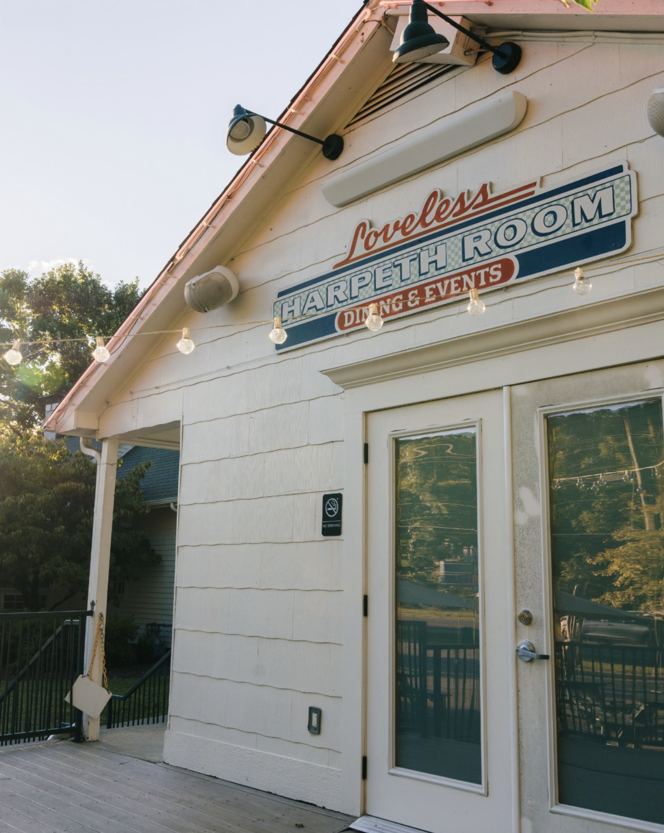The exterior of a white building with a sign that reads 'Loveless Harpeth Room Dining & Events'.