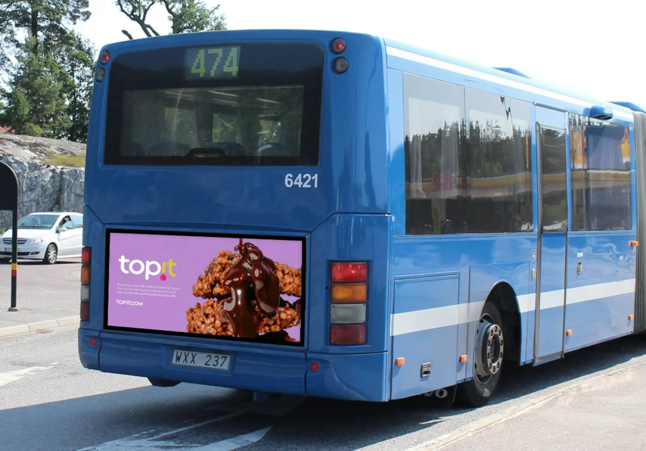 Back of a blue bus with an advertisement for fried chicken topped with chocolate sauce on the rear digital display and a digital route number 474 at the top.