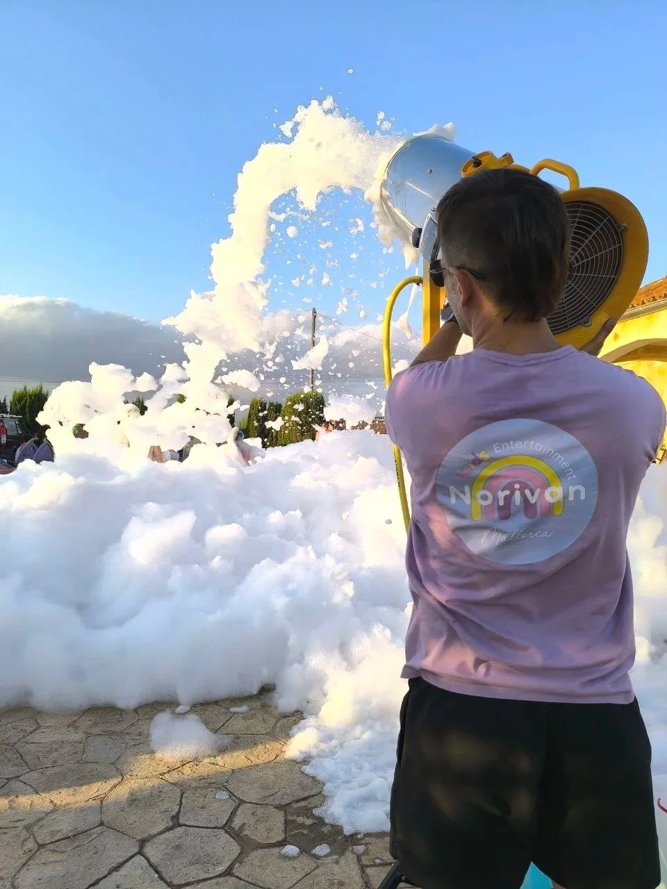 Happy kids and adults dancing inside a massive cloud of safe foam party entertainment in Marratxi Mallorca.