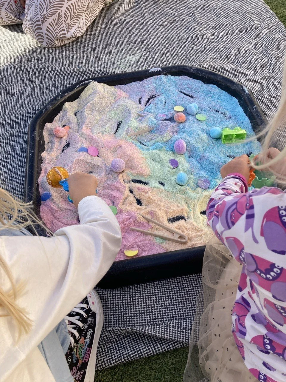 Kids between 1-6 exploring Montessori inspired sensory bins at a kids event in Arta Mallorca.