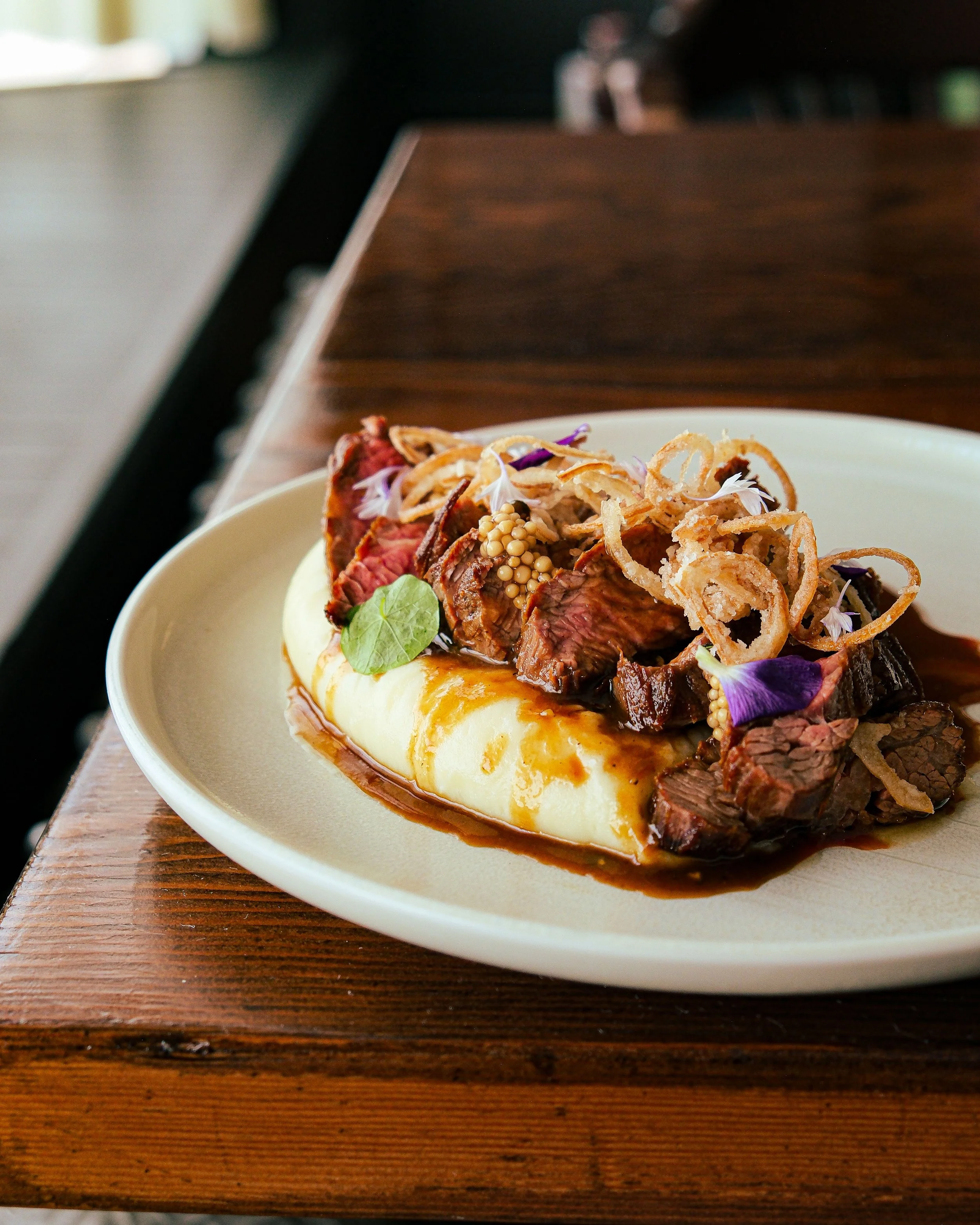 Our Bavette dish, served with rich pomme aligot, shallot jus, and crispy shallots