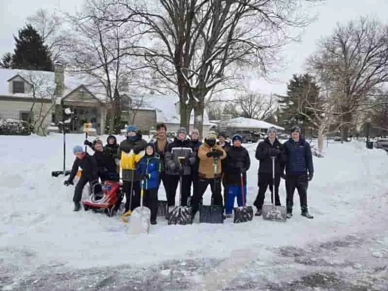 Bexley Football Middle School Group of people standing in snowy yard with shovels and snow gear