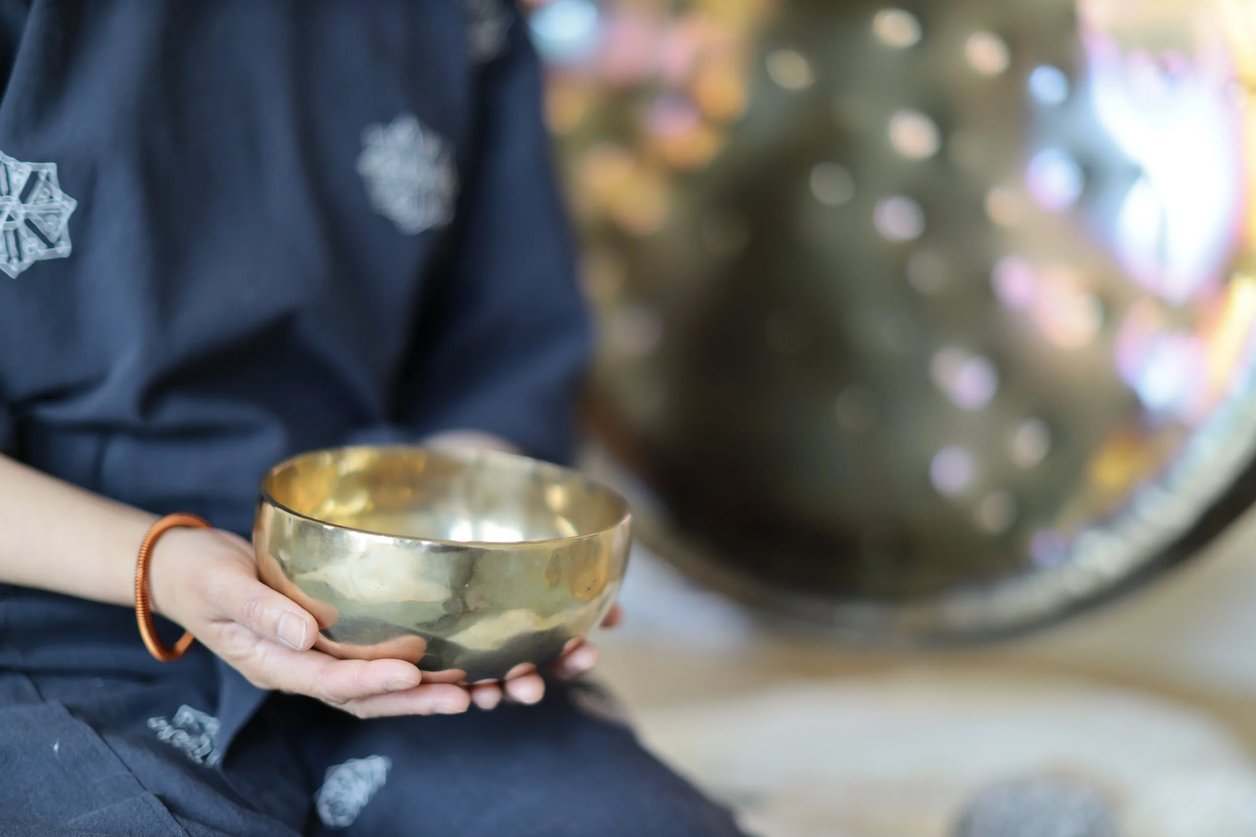 Sound healing practitioner holding a Himalayan singing bowl during a personalised sound healing session at Harmony Sound Healing in Sutton, Surrey.