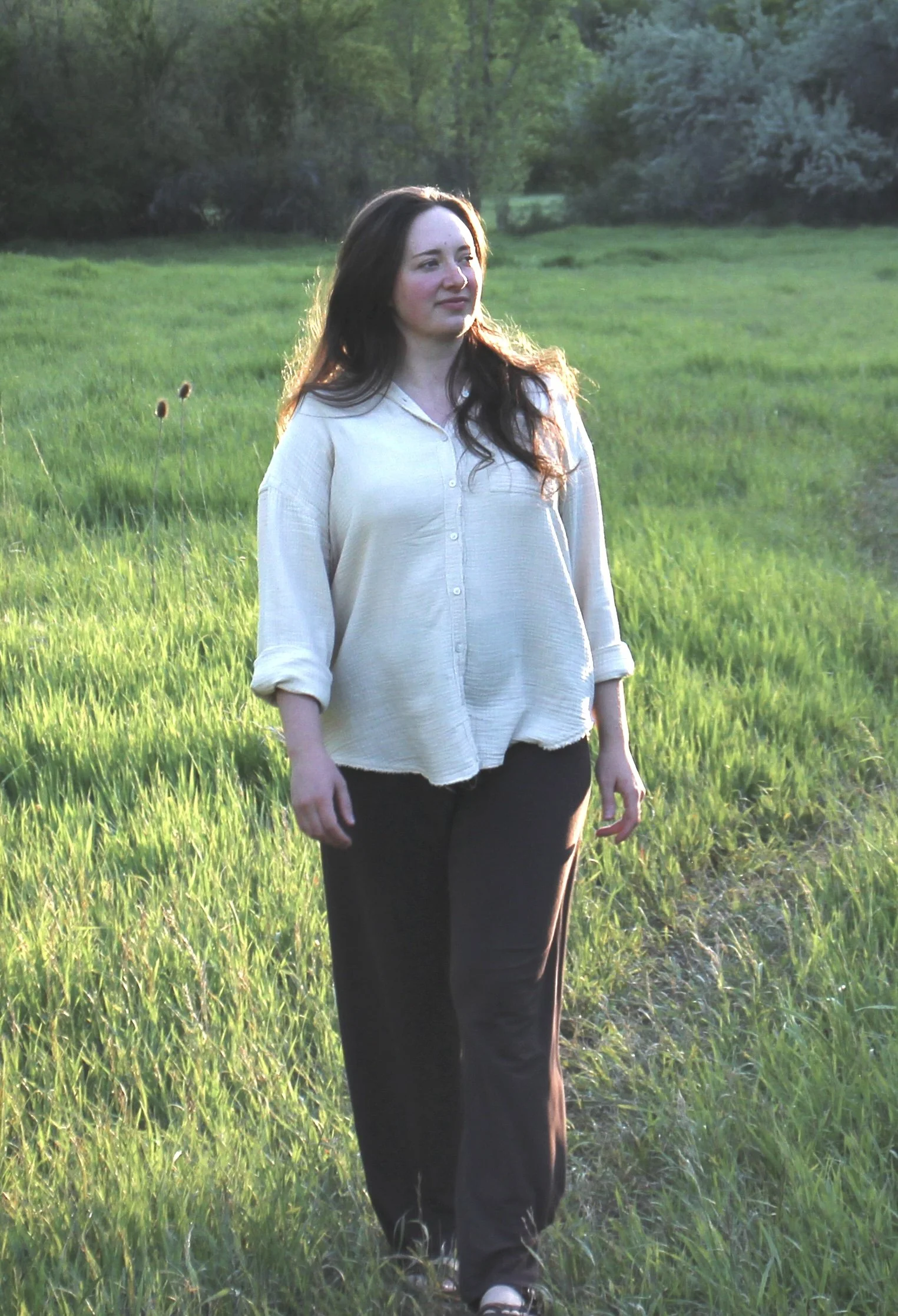 ERP therapist walking through a grassy meadow at golden hour with a calm focused expression