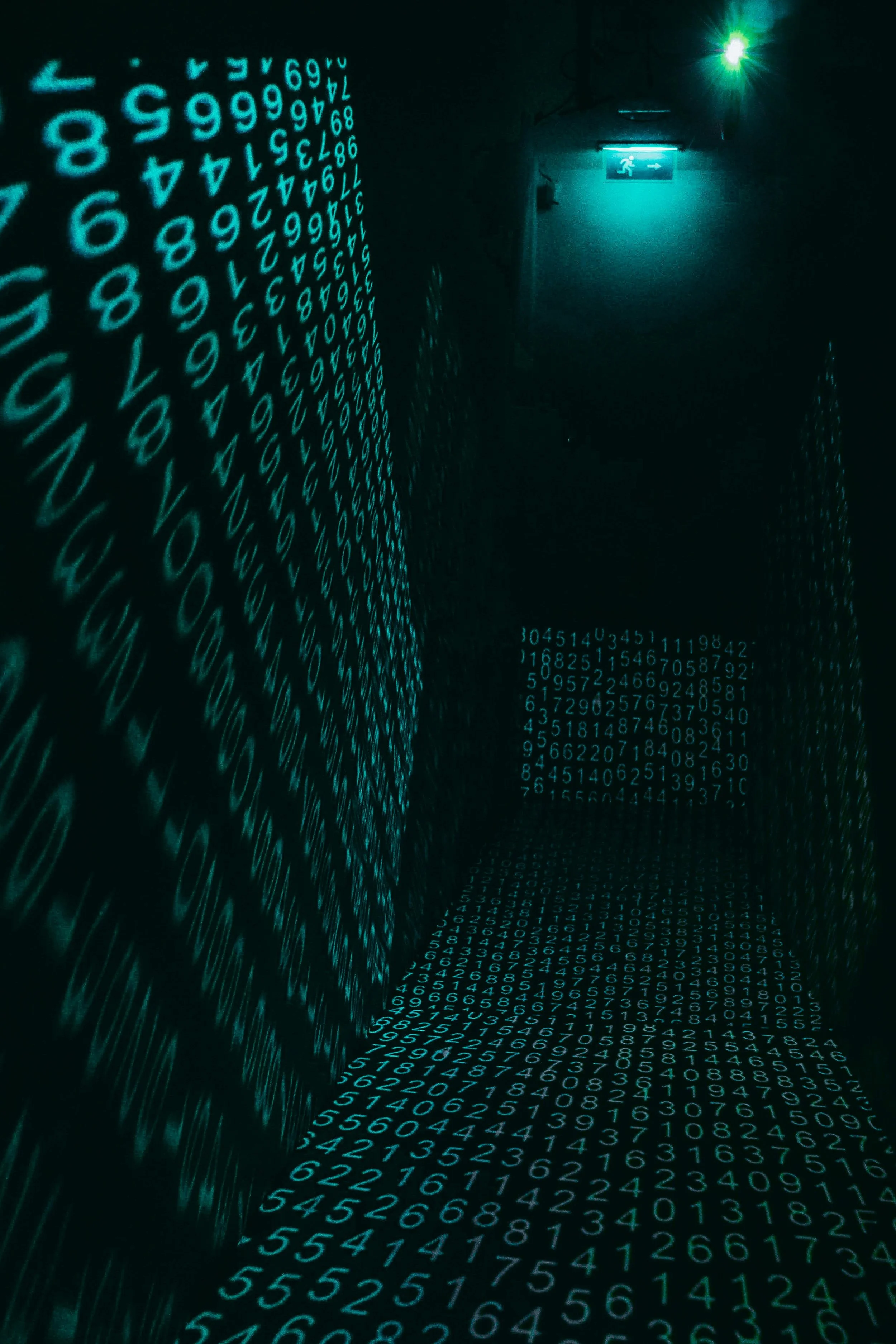 A dark hallway illuminated by blue-green digital numbers and a green exit sign with an arrow.