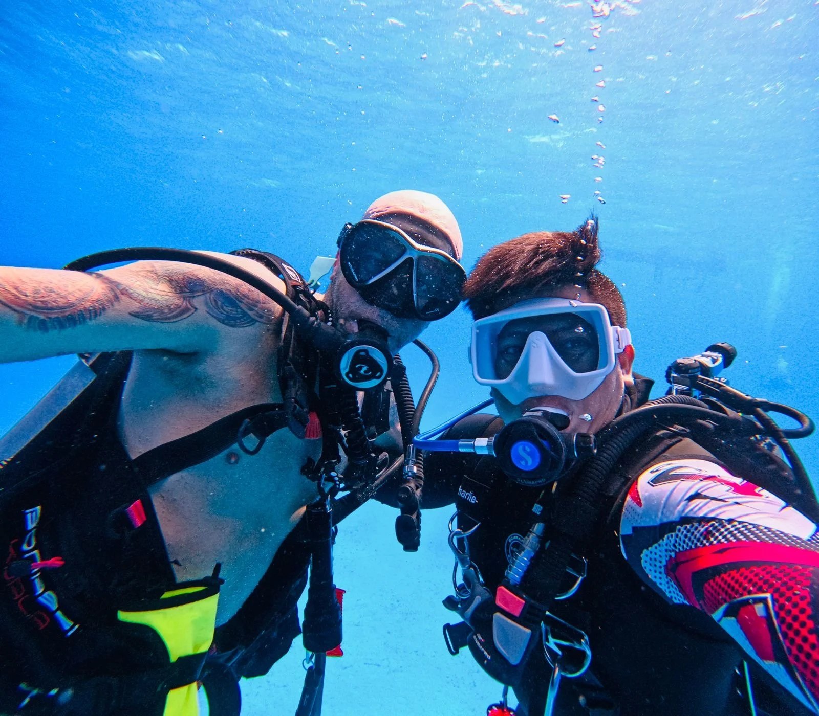 Two scuba divers underwater taking a selfie.