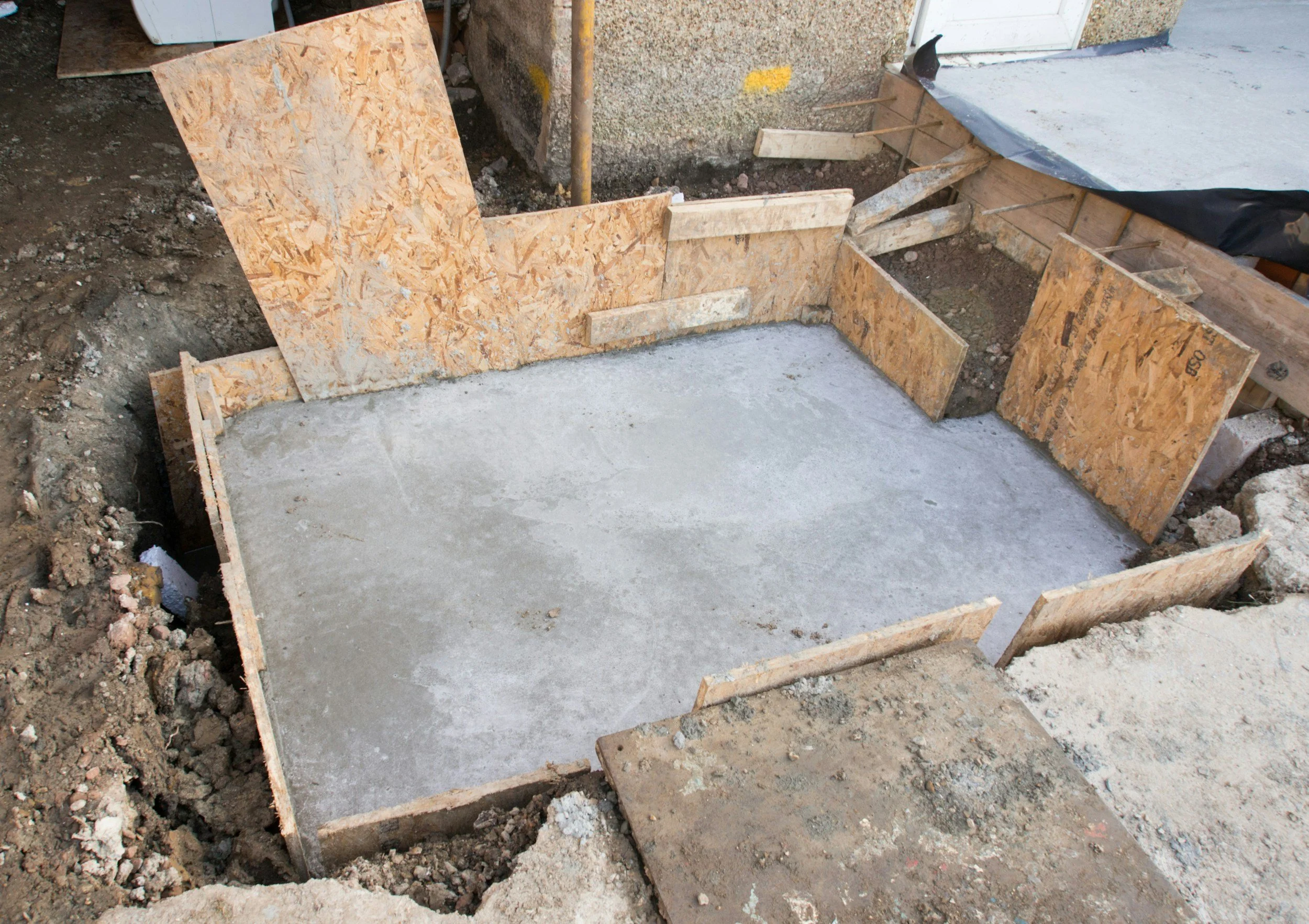 Concrete foundation slab poured within wooden forms at a job site