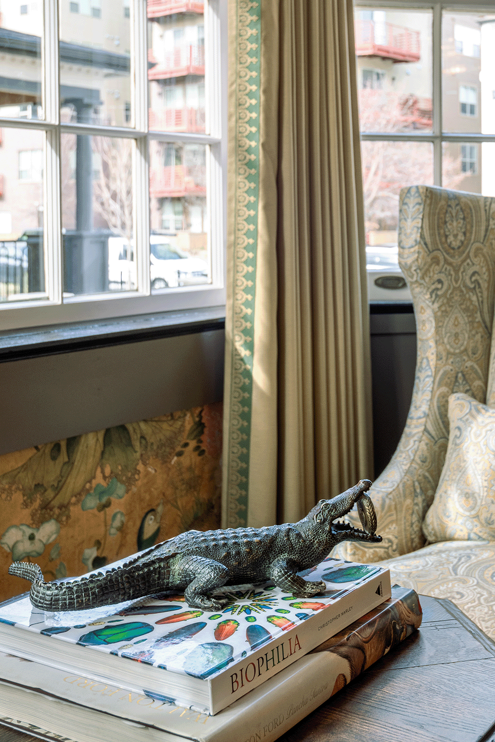 Bronze alligator accessory atop coffee table books.