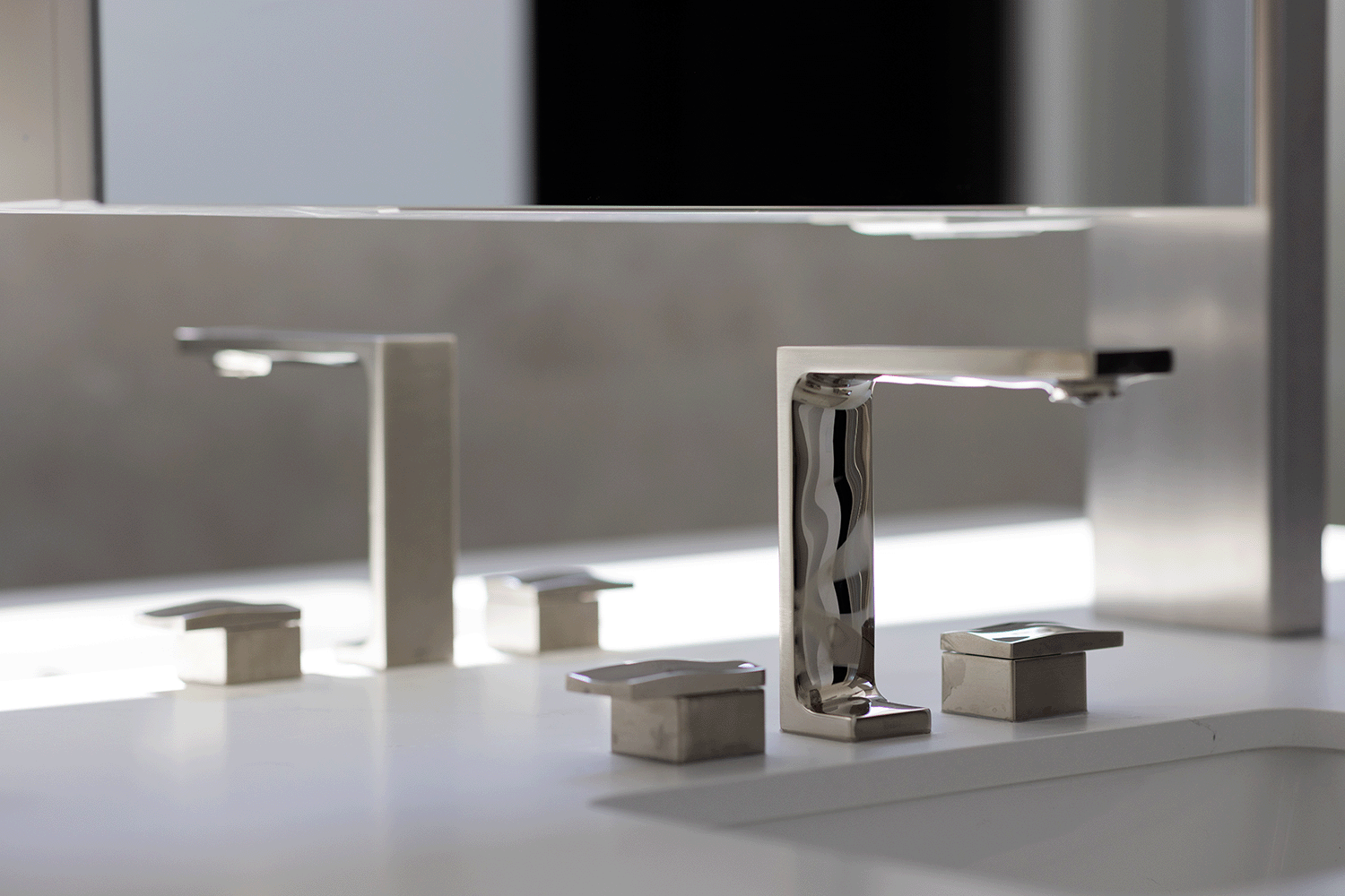 Chrome faucet mimics the myriad textures created by water as it sculpts, polishes and erodes the materials around it.