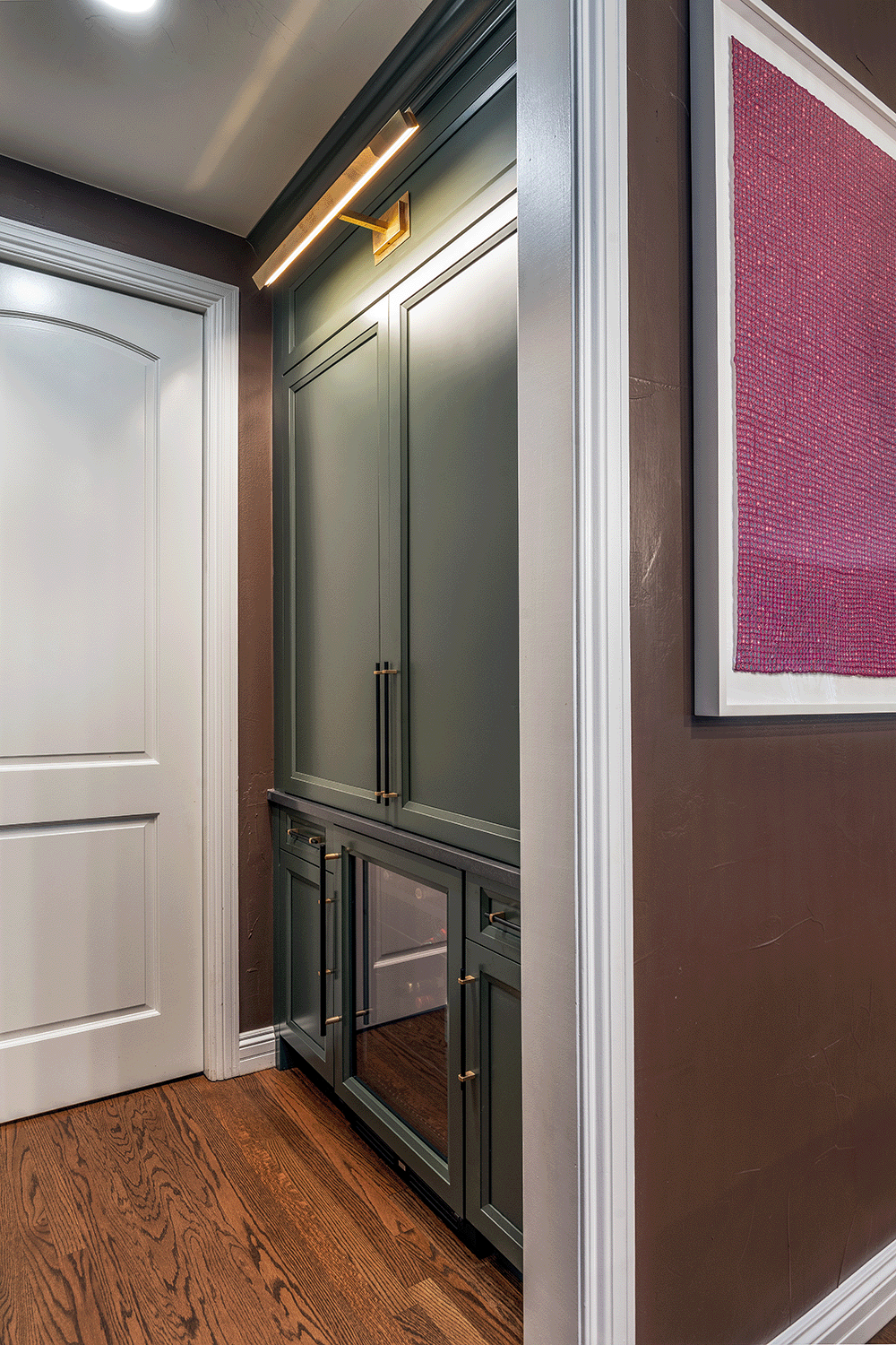 Butler's pantry featuring cocktail bar and picture lights mounted to the cabinet face.