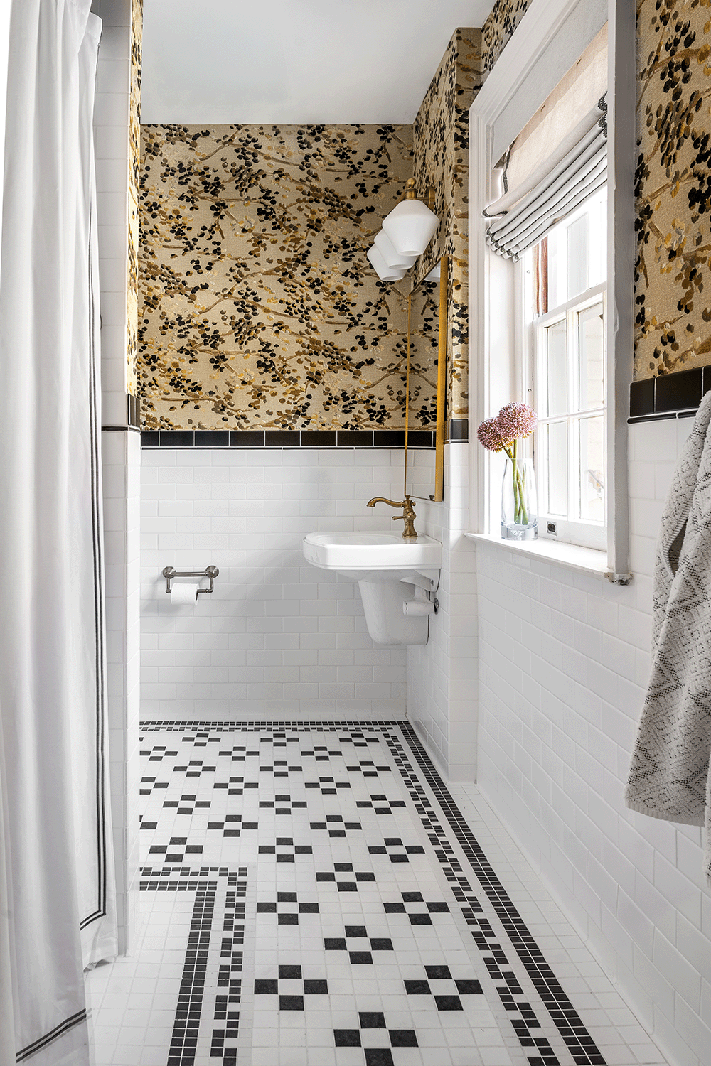 Bathroom with custom patterned tile floors and abstract floral wallpaper.