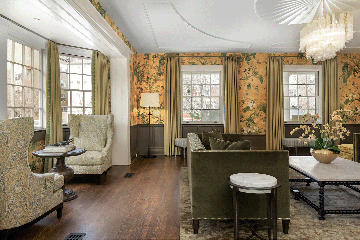 Historic home's Parlour featuring colorful floral wallpaper, delicate chandelier and custom furnishings.
