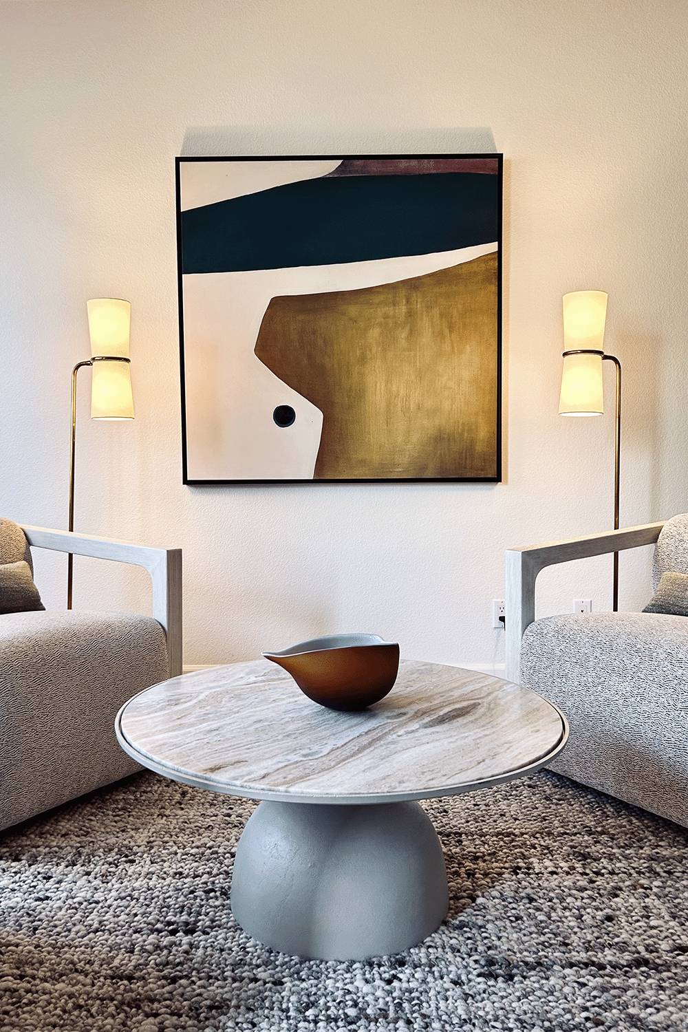Seating area with swivel chairs, modern artwork and contemporary floor lamps.