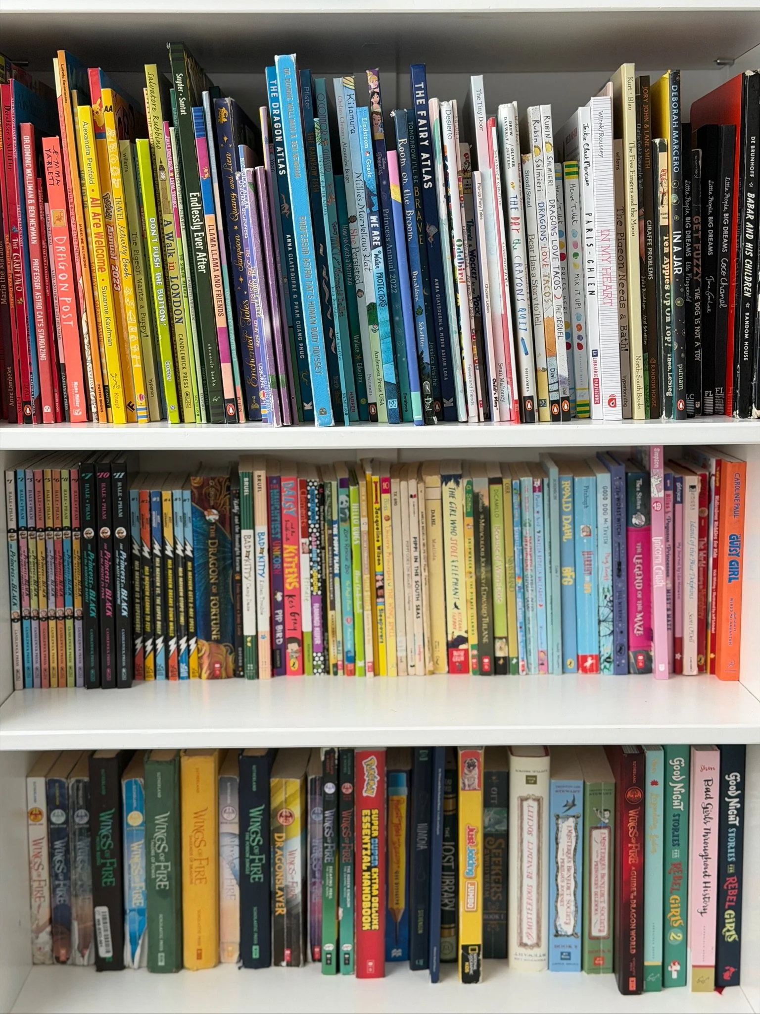 Bookshelves filled with children's books and graphic novels in a library or bookstore.