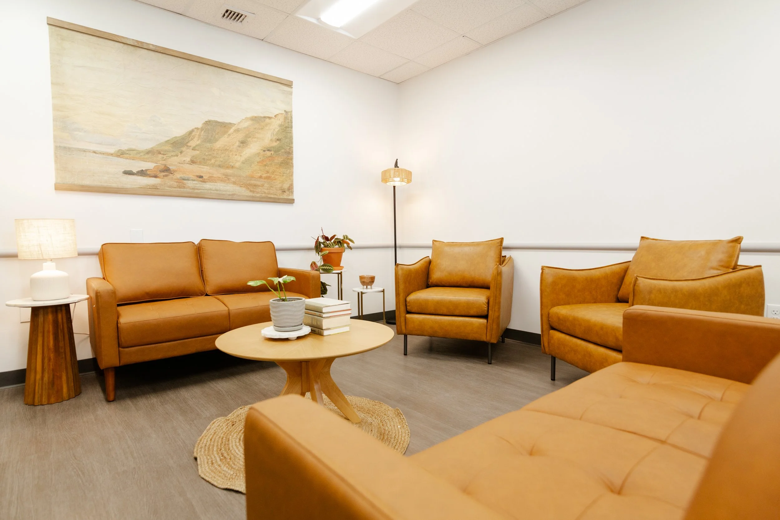 A cozy waiting room with tan leather sofas
