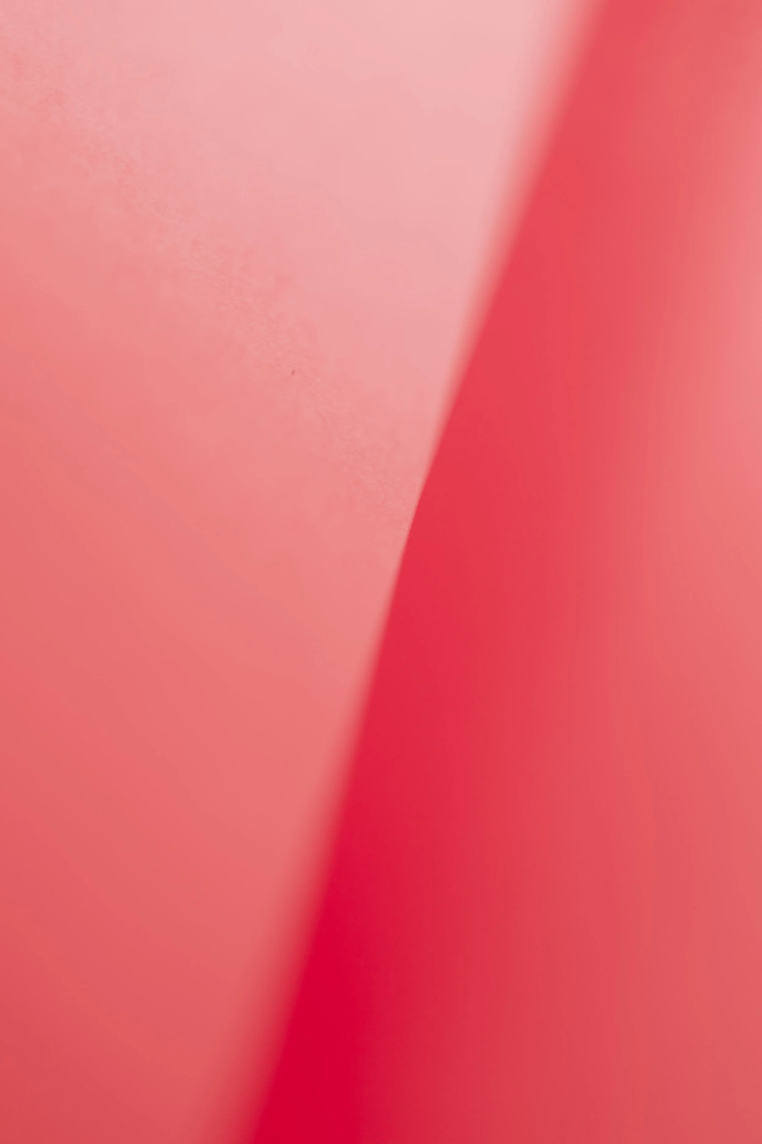 Close-up of pink and red paper or fabric with a soft gradient transition.
