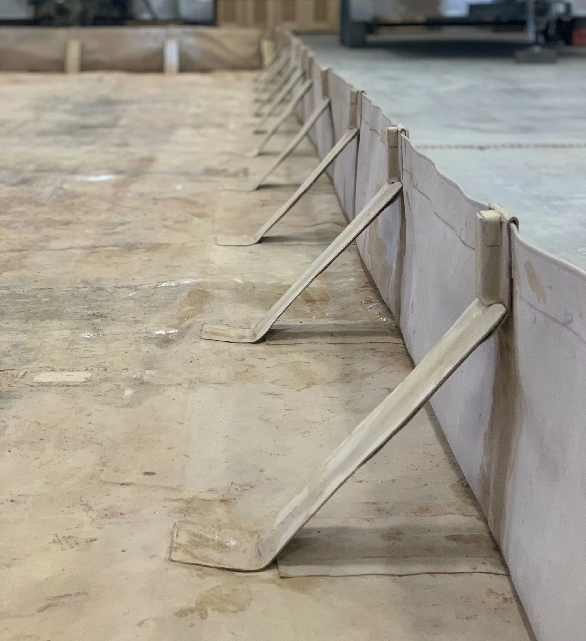 Wooden forms and braces on a concrete floor in a construction site.