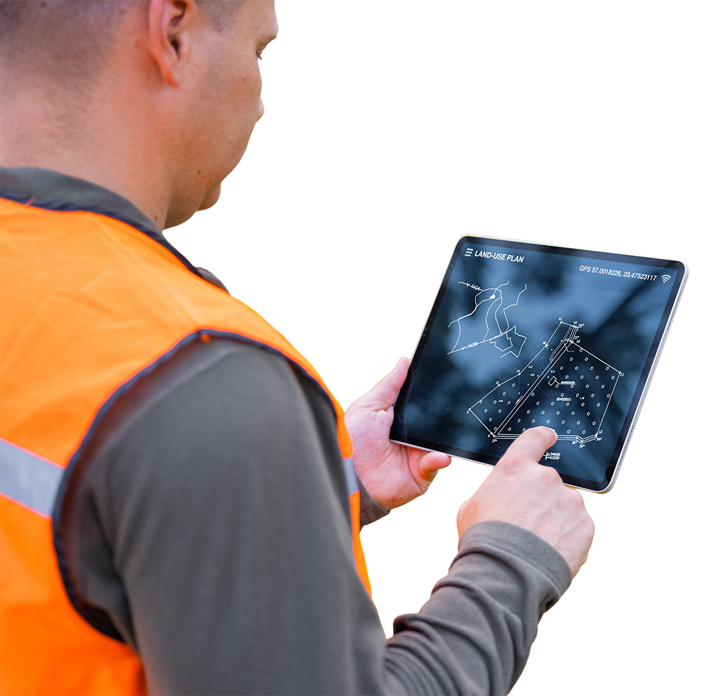 A person wearing an orange safety vest using a tablet with a land use plan displayed.