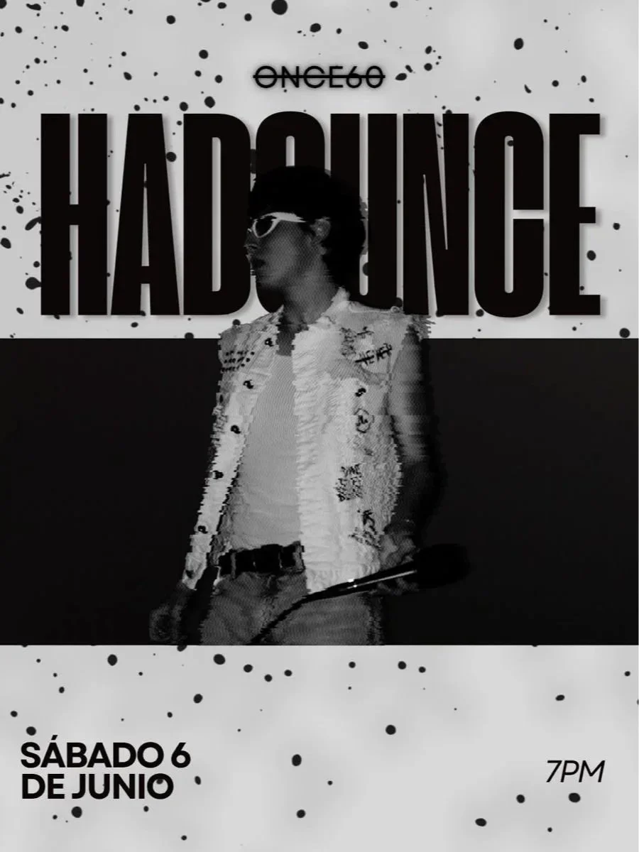 Cartel en blanco y negro promocionando una presentación artística con la palabra 'HADOUCE' en letras grandes y la imagen de un hombre con gafas, camisa de mezclilla y sosteniendo un micrófono, con detalles en splashes y marcas de tinta.