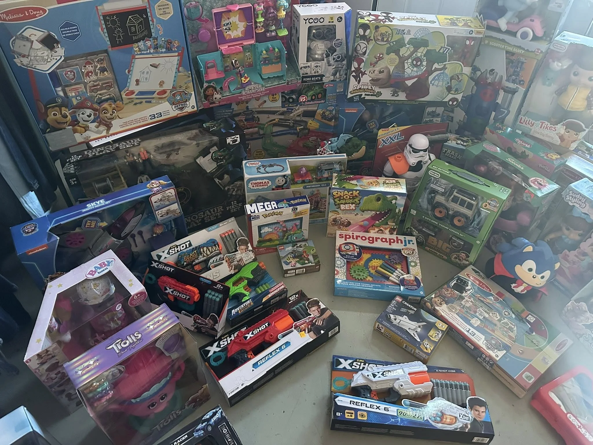 Display of various children's toys including action figures, craft kits, toy guns, and plush toys.