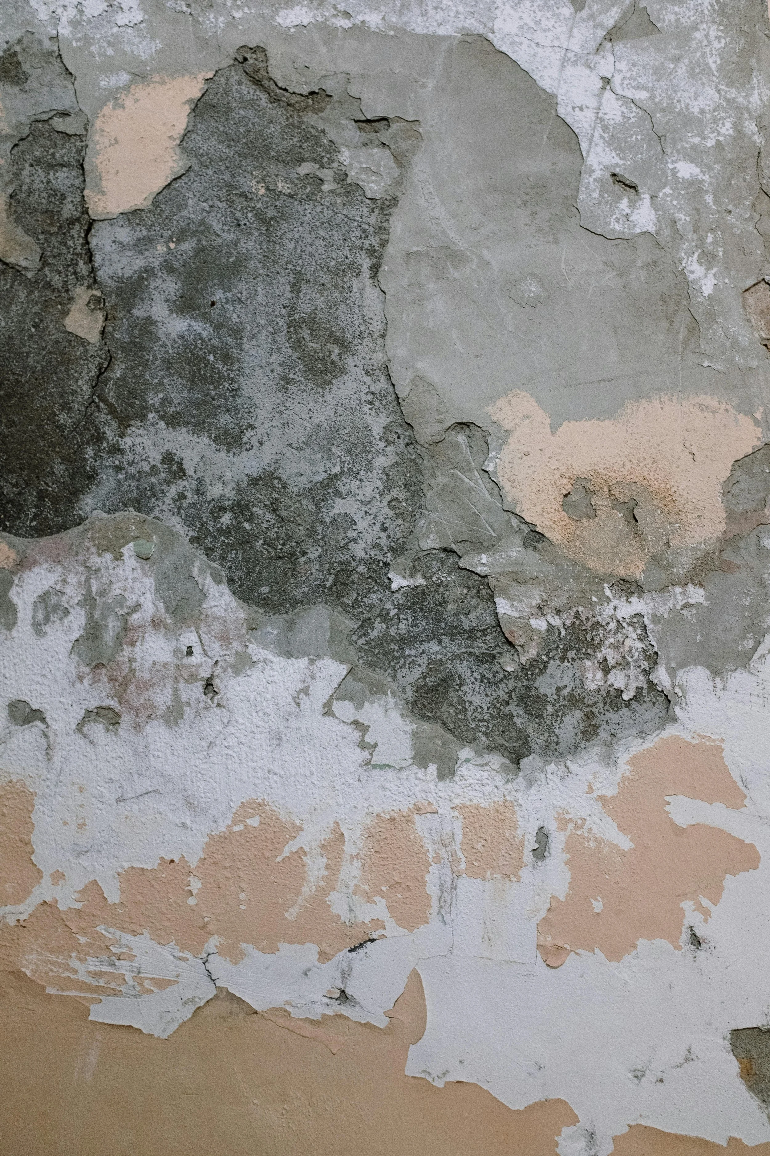 Eine Wand mit alten, abgeblätterten Farbschichten in verschiedenen Farben und Texturen.