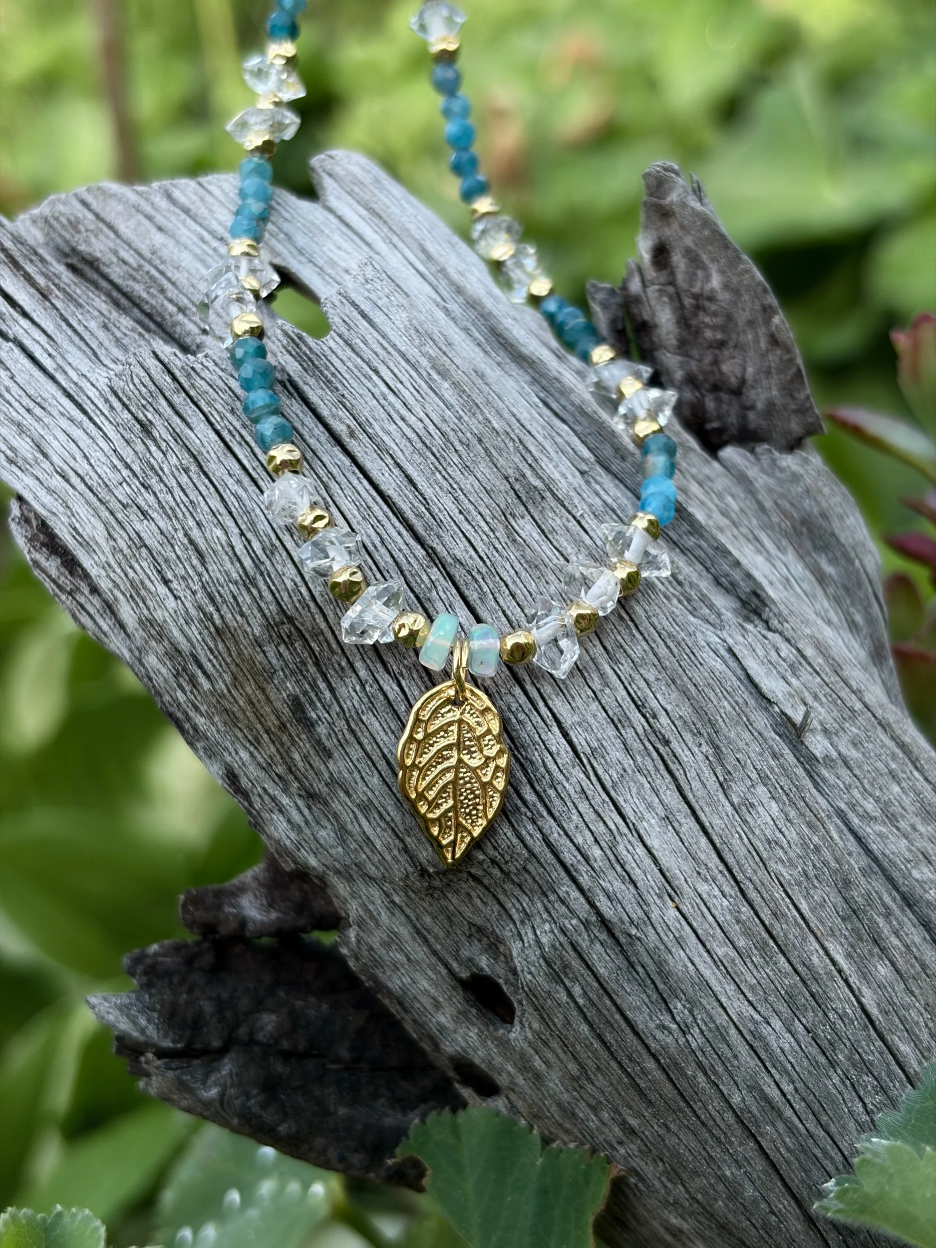 Edelsteinkette AURELIS mit Edelopal und Apatit auf Holz fotografiert