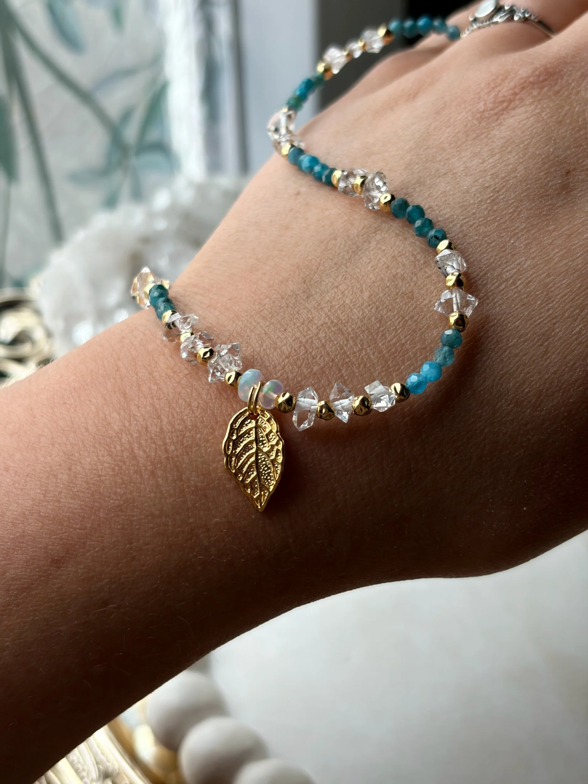 Handgefertigte Edelsteinkette AURELIS mit Edelopal auf der Hand präsentiert